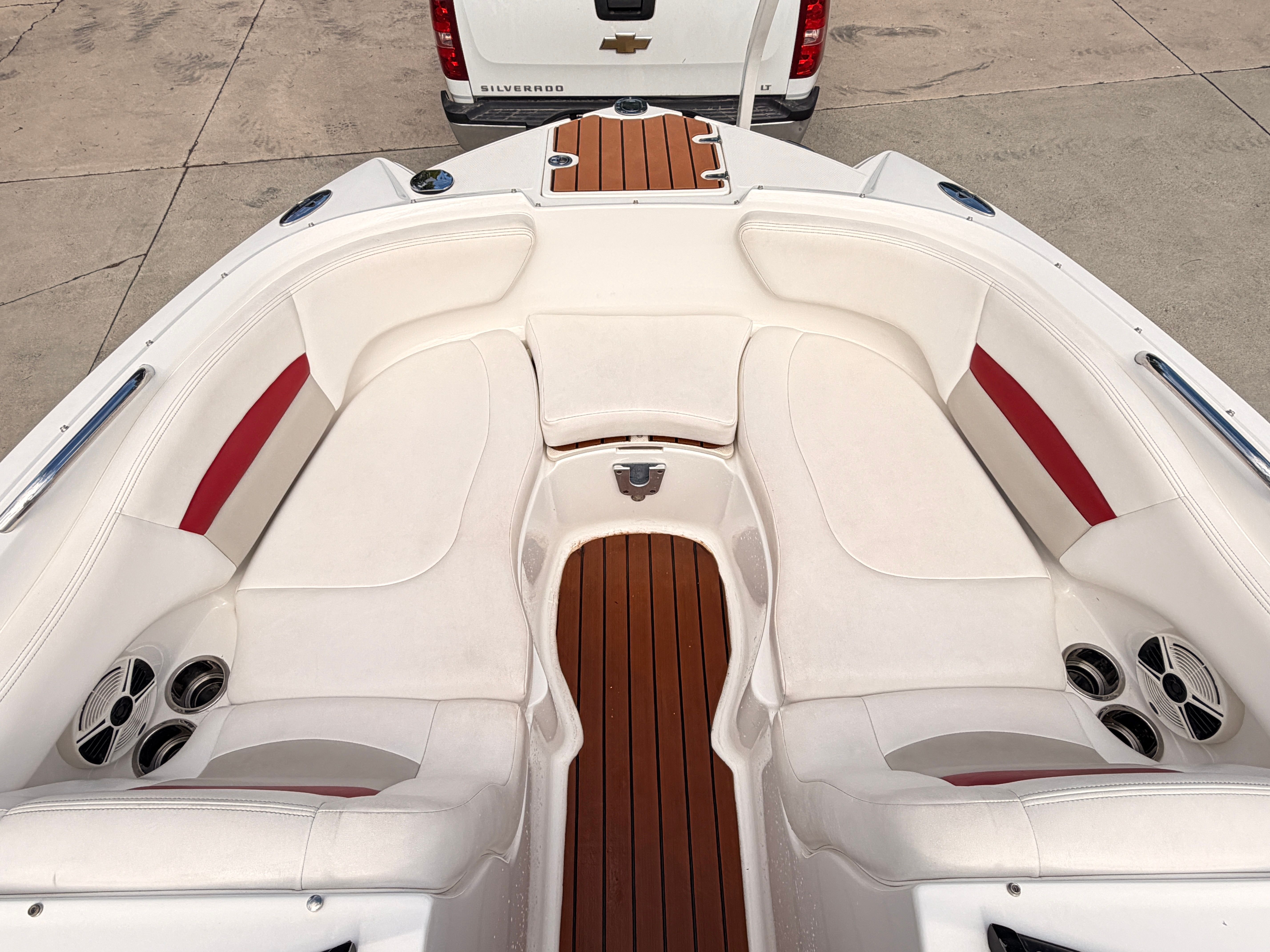 The image shows the bow area of a 2008 Chaparral Sunesta 224 with white upholstery and wood flooring.