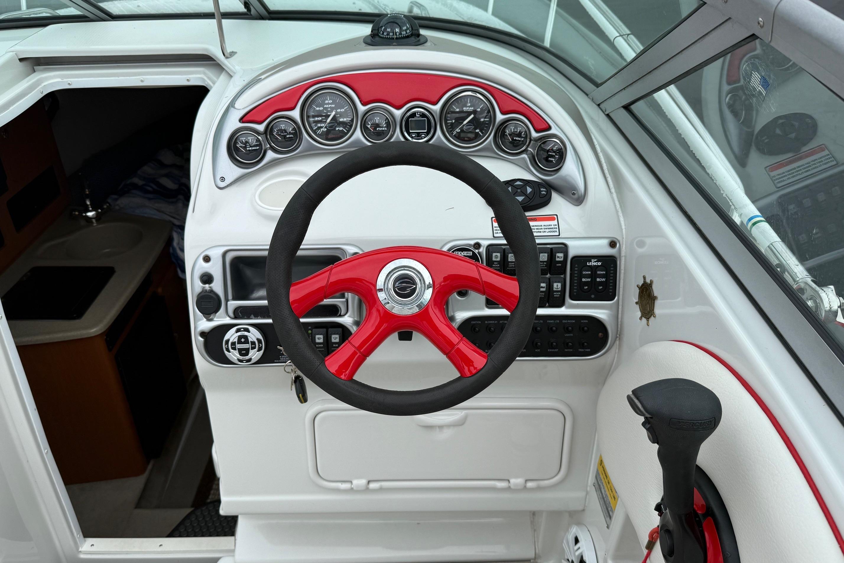 2005 Crownline 250 CR boat dashboard with red steering wheel and control panel.
