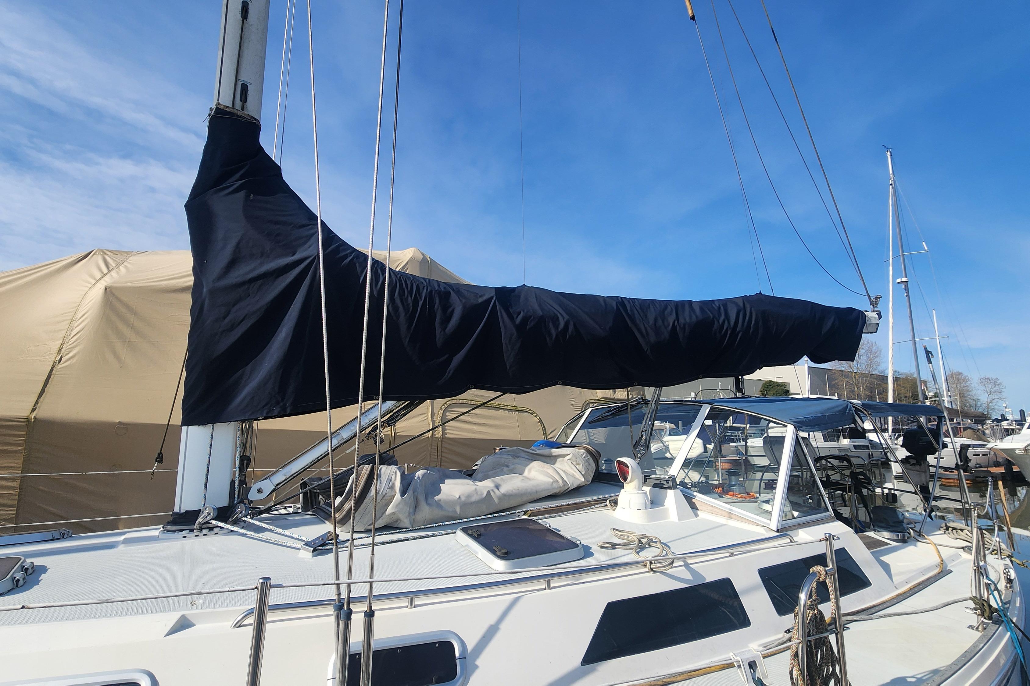 1993 Catalina 42 sailboat with covered mainsail, docked under clear blue sky.