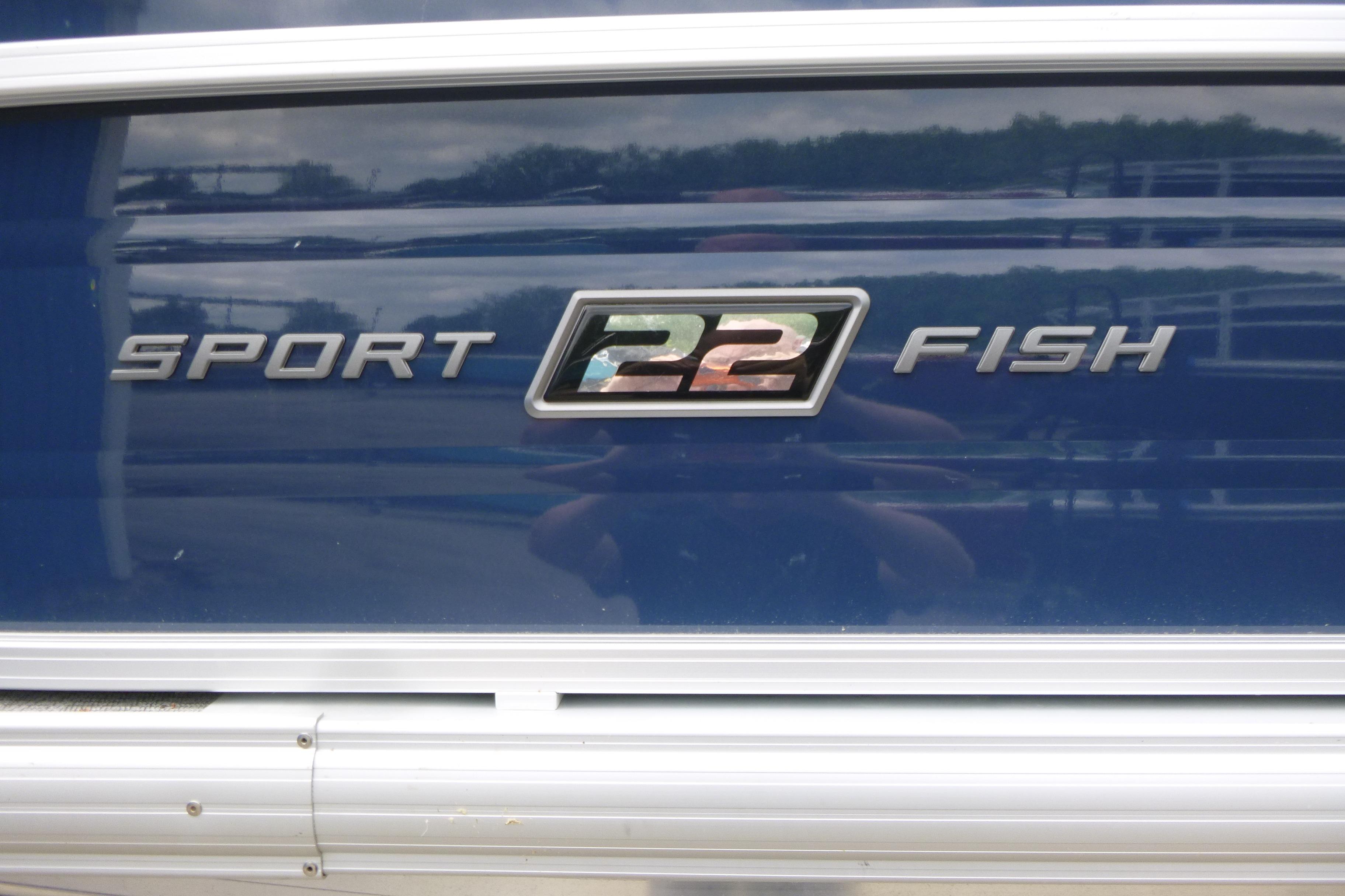 2026 Sun Tracker SportFish 22 DLX boat logo on blue background.