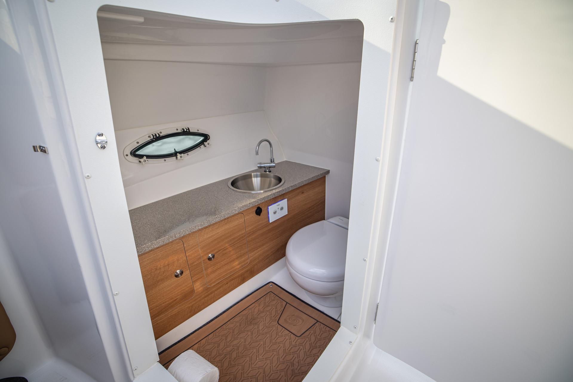 2026 Hurricane SunDeck 2690 OB boat interior bathroom with sink and toilet.
