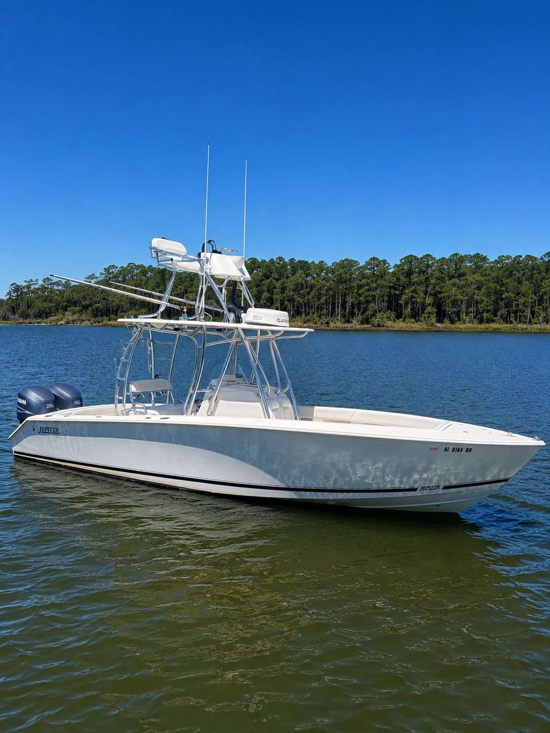 2011 Jupiter 29 boat on calm water with forest backdrop.