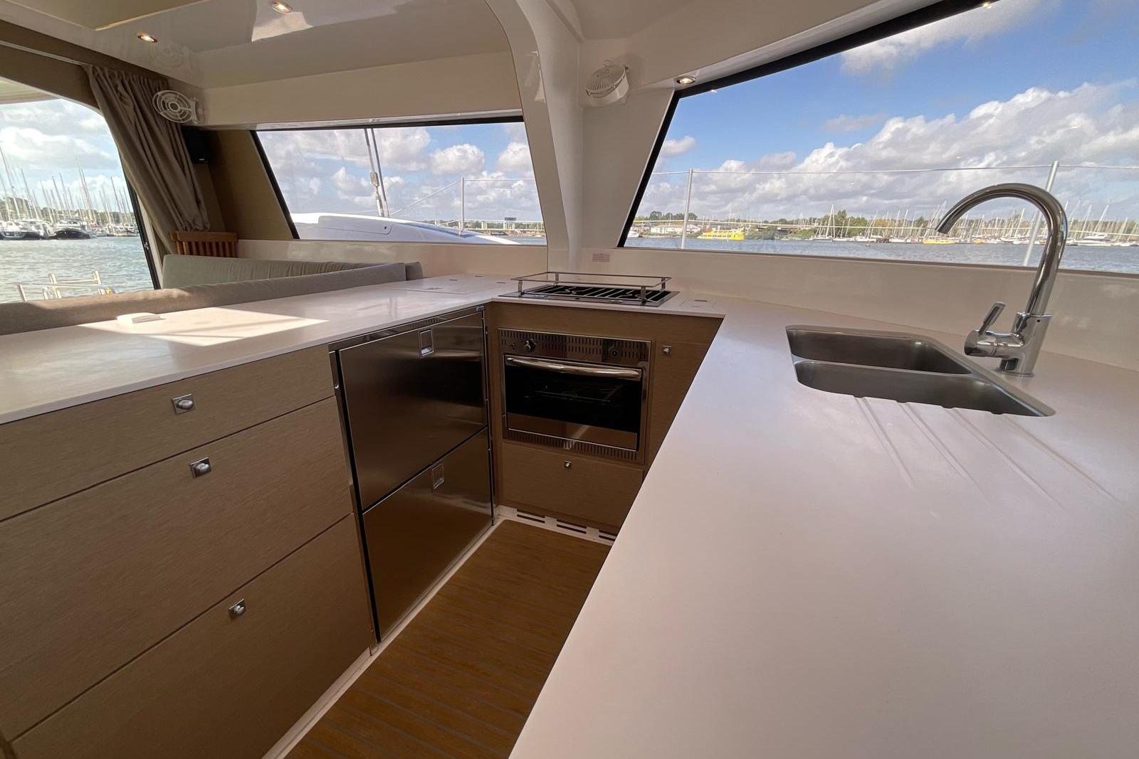 Modern kitchen interior of 2020 NEEL 47 trimaran with sleek countertops and ocean view.