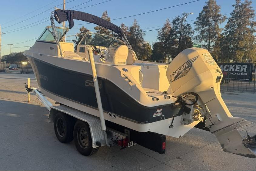 2006 Seaswirl Striper 2101 Dual Console OB boat on trailer, featuring Johnson outboard motor.