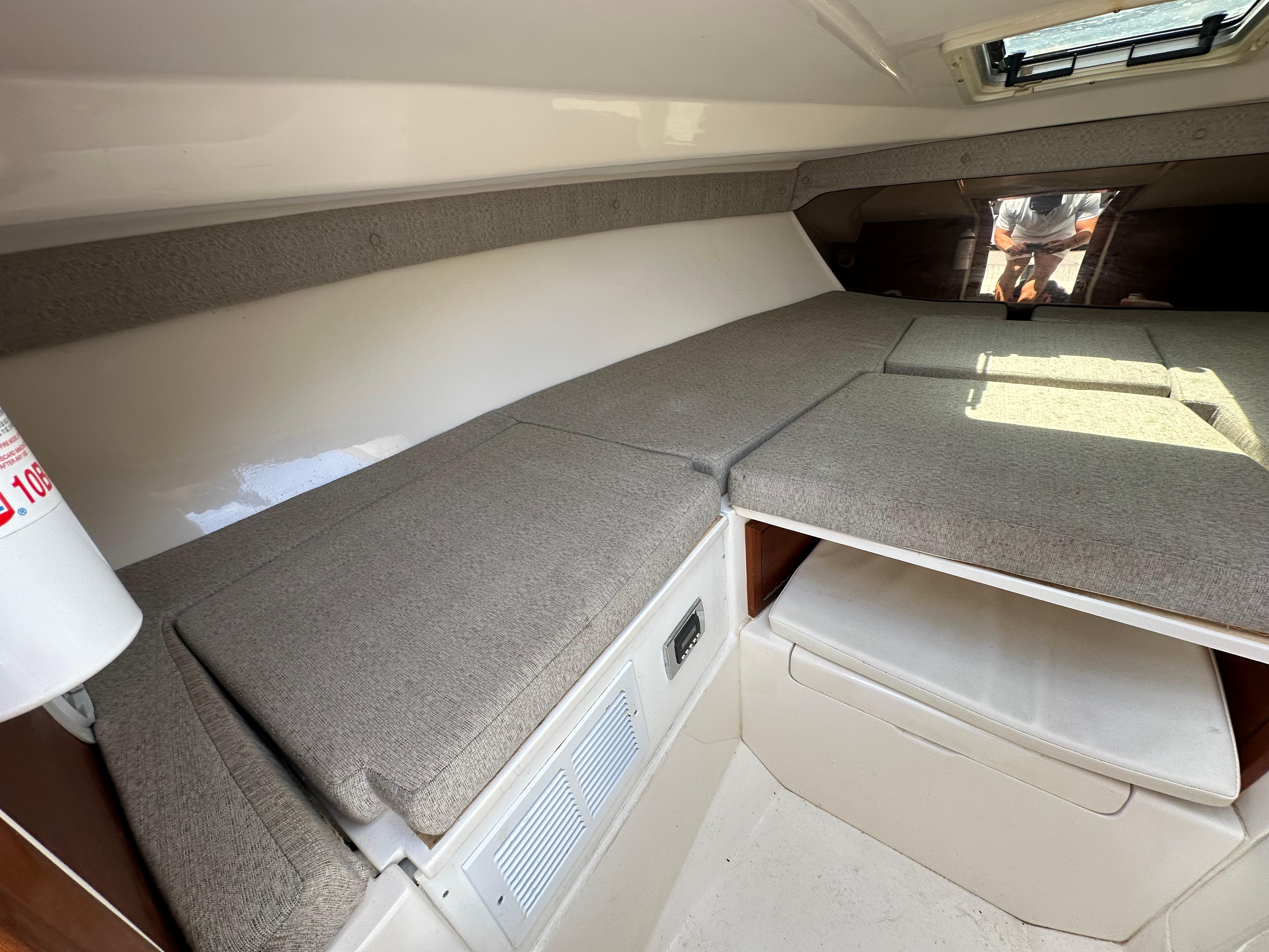Interior of 2002 Intrepid 323 Cuddy boat with cushioned seating and storage.