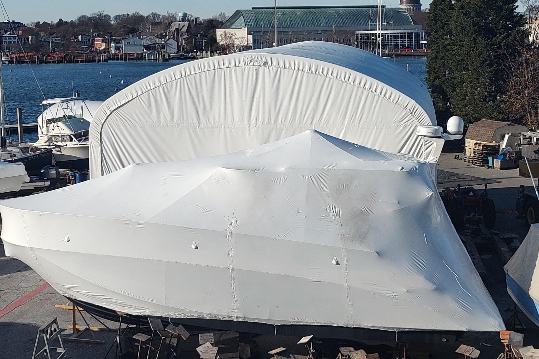 2021 Regal 42 Fly yacht covered in protective wrap at a marina.