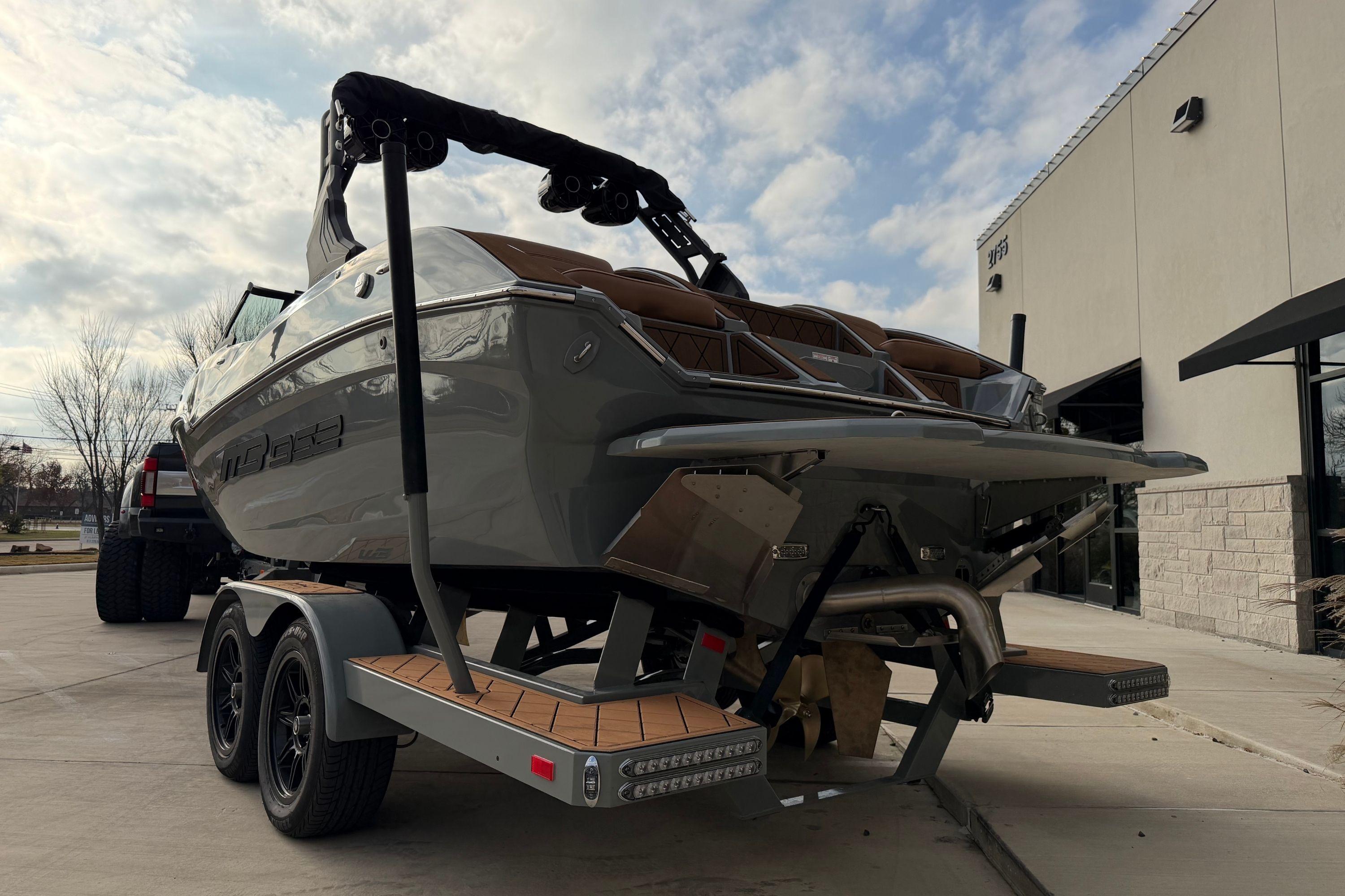 2026 MB B52 21 Alpha boat on trailer, parked outside a building under a cloudy sky.