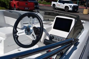 Steering wheel and dashboard of 2026 Tahoe T16 boat in a parking lot.