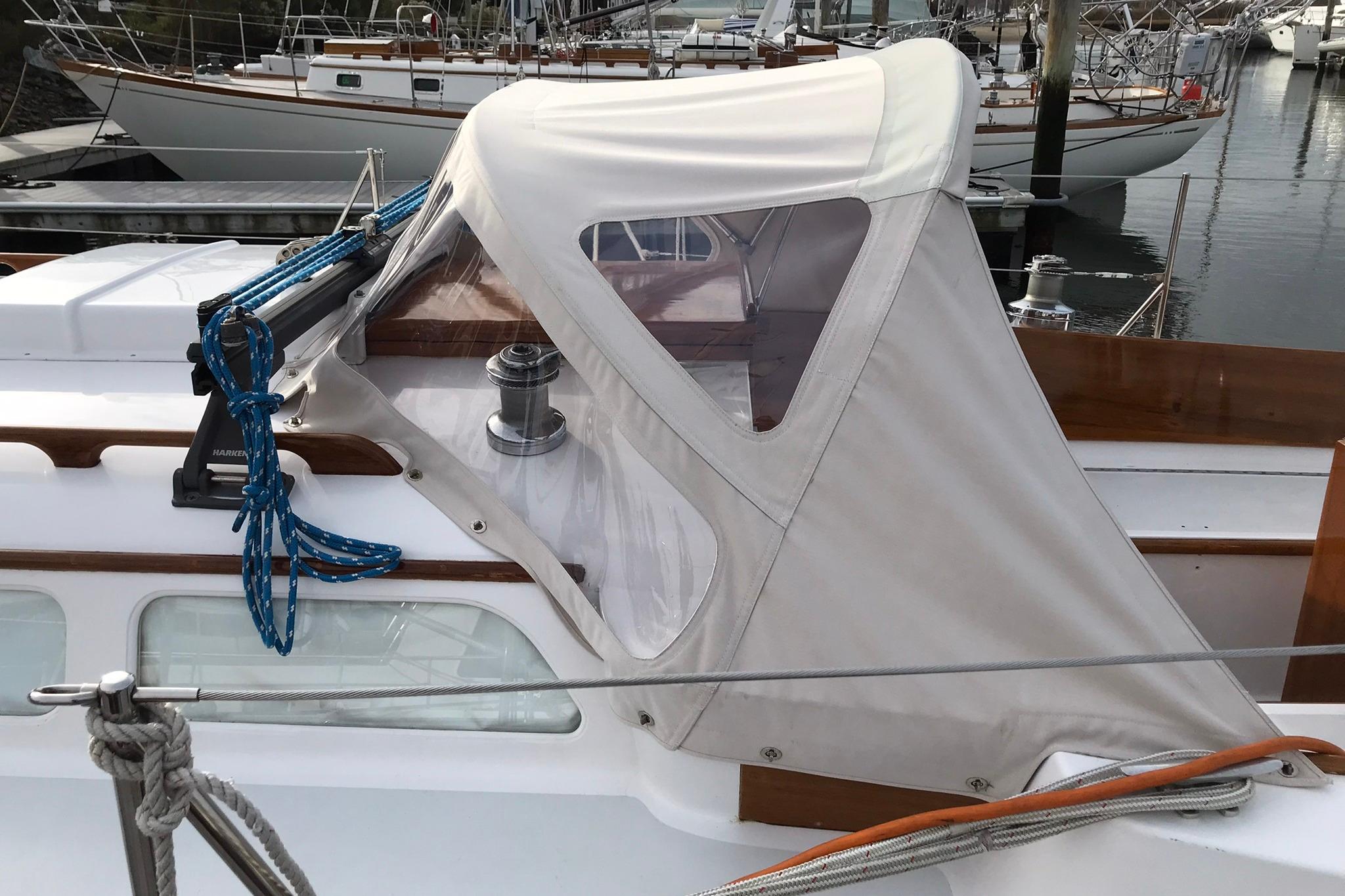 1970 Hinckley Bermuda 40 sailboat with protective canopy and blue ropes at a marina.