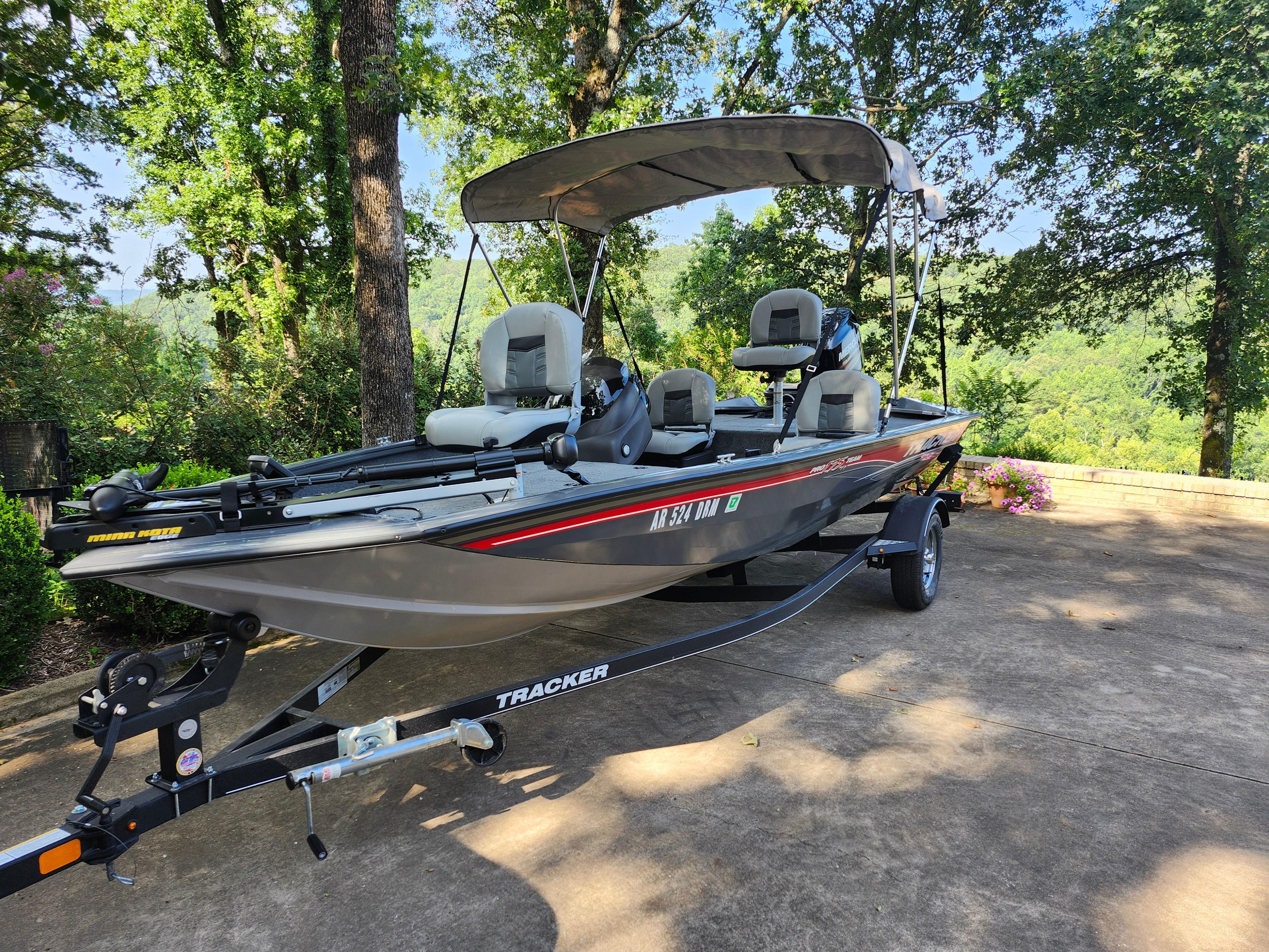 2018 Tracker Pro 175 TF boat on trailer, parked outdoors with lush greenery.