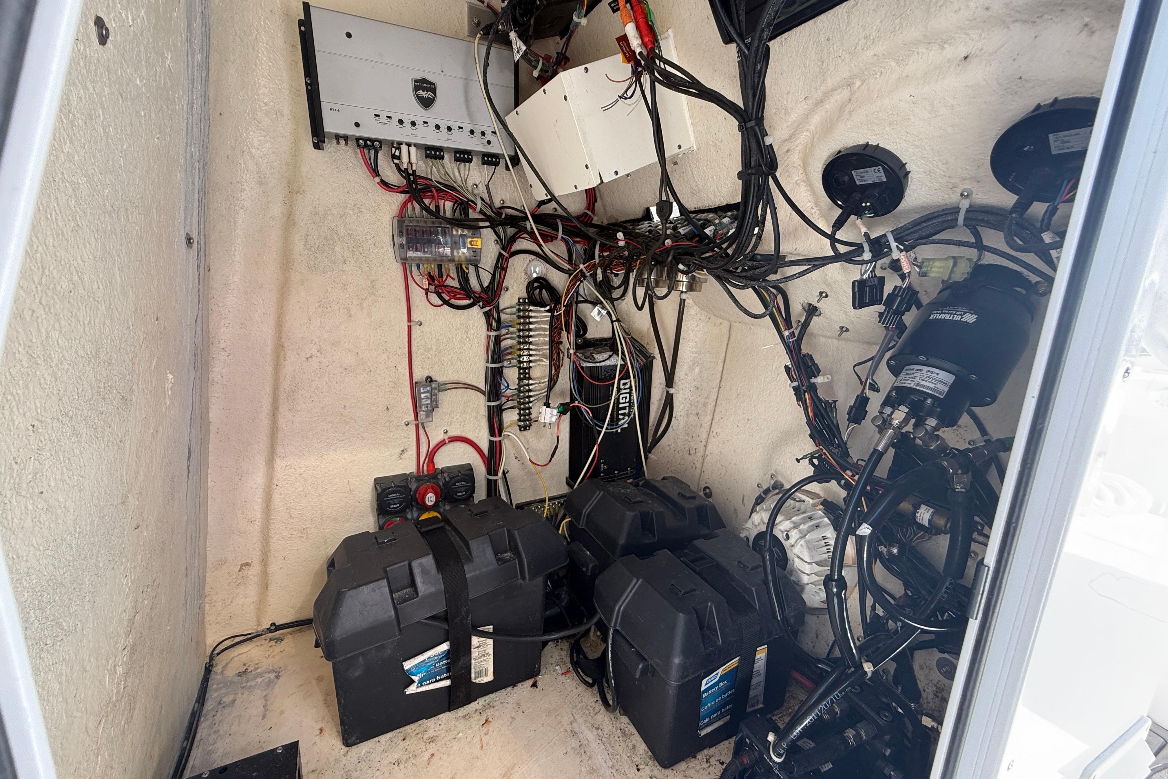 Electrical system inside 2020 Tideline 235 Hybrid boat, featuring batteries and wiring.