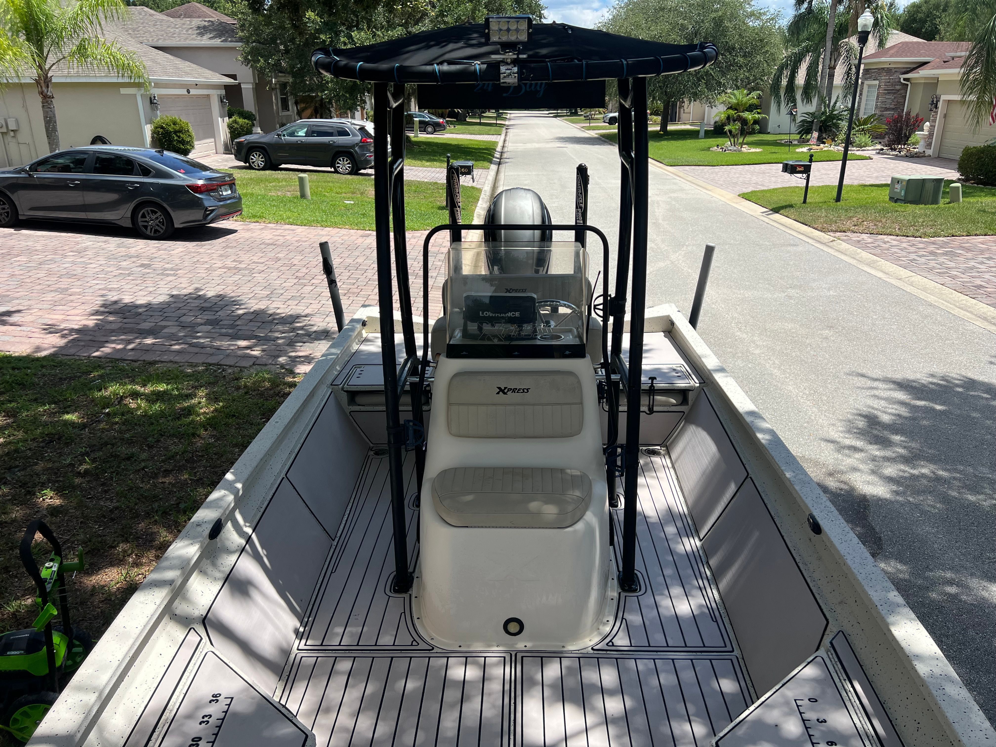 2016 Xpress H24B Bay boat parked on a residential street.