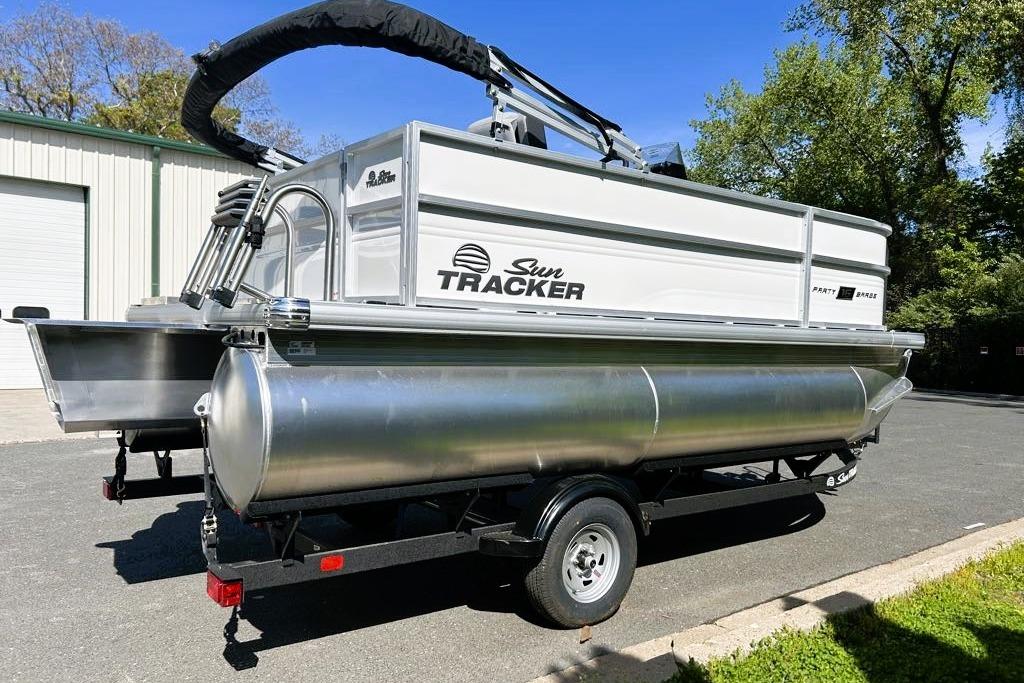 2026 Sun Tracker Party Barge 16 DLX pontoon boat on trailer, parked outdoors.