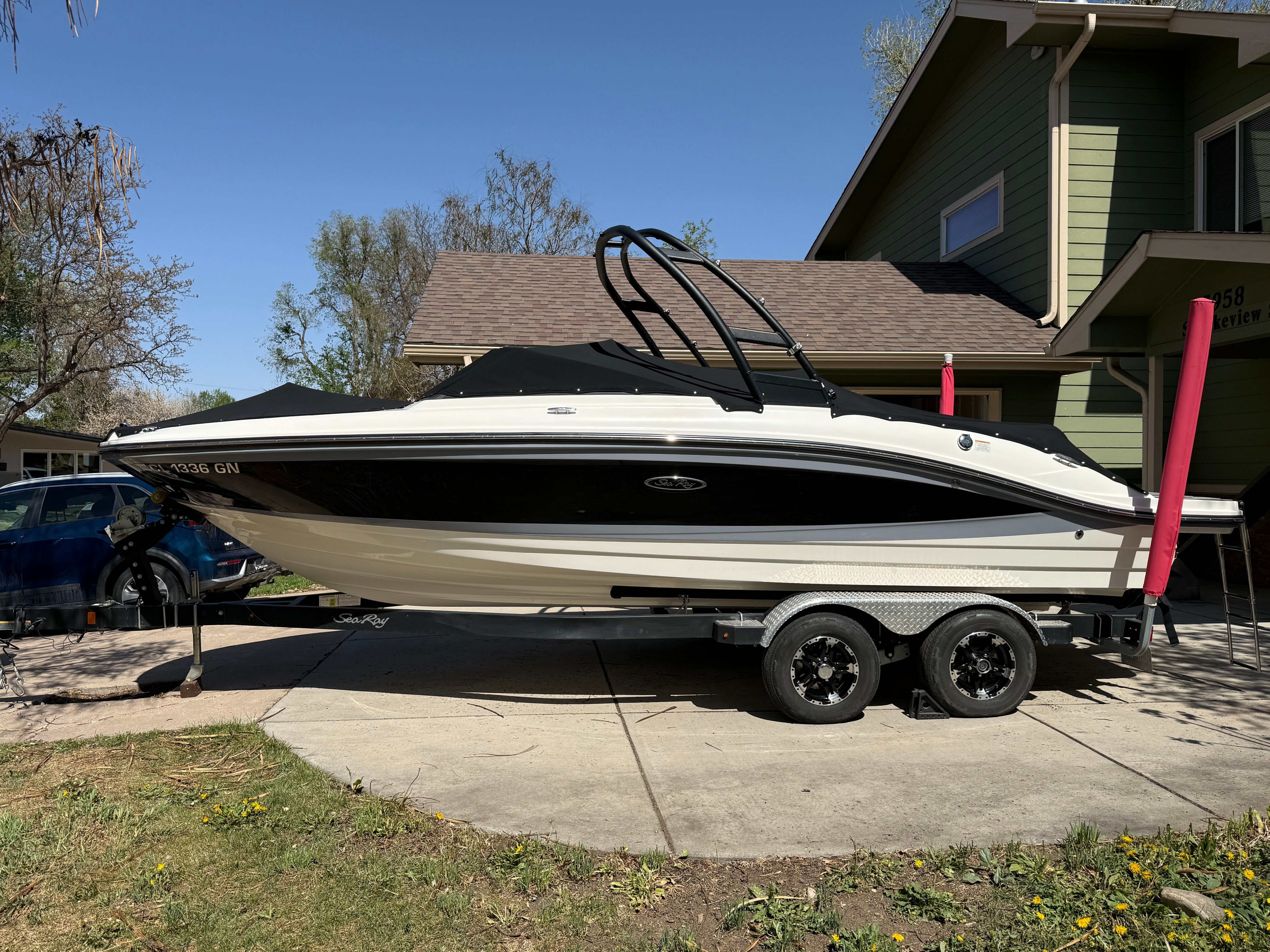 2022 Sea Ray SPX 210 boat on trailer in front of house.