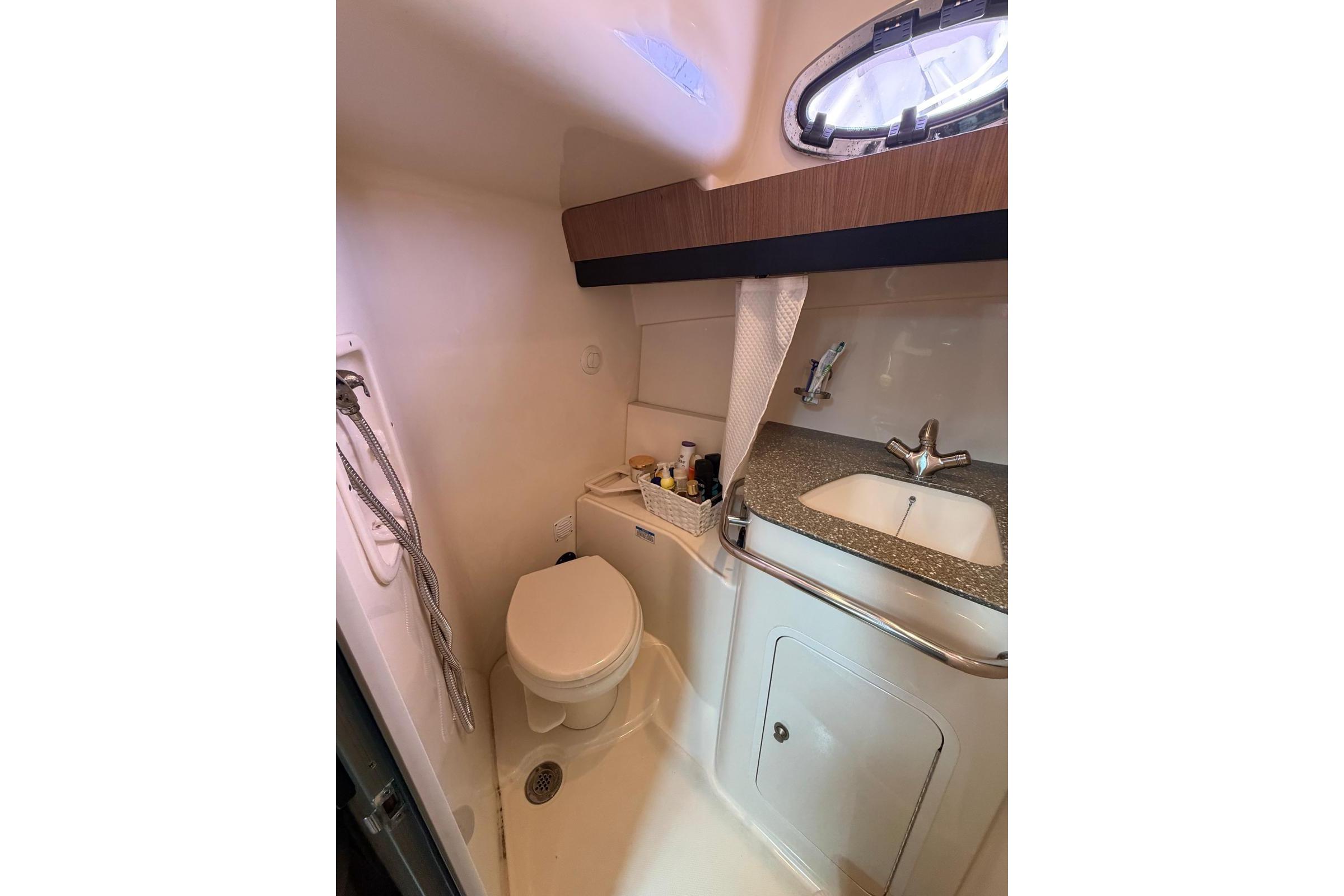 2012 Boston Whaler 345 Conquest bathroom with toilet, sink, and showerhead.
