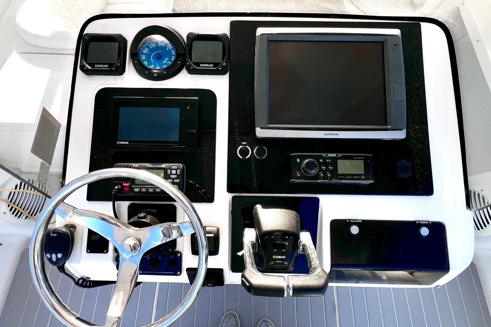 2002 Intrepid 366 boat dashboard with Garmin and Yamaha controls, steering wheel, and navigation instruments.