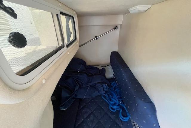 2003 Sea Ray 260 Sundancer cabin interior with window and blue upholstery.