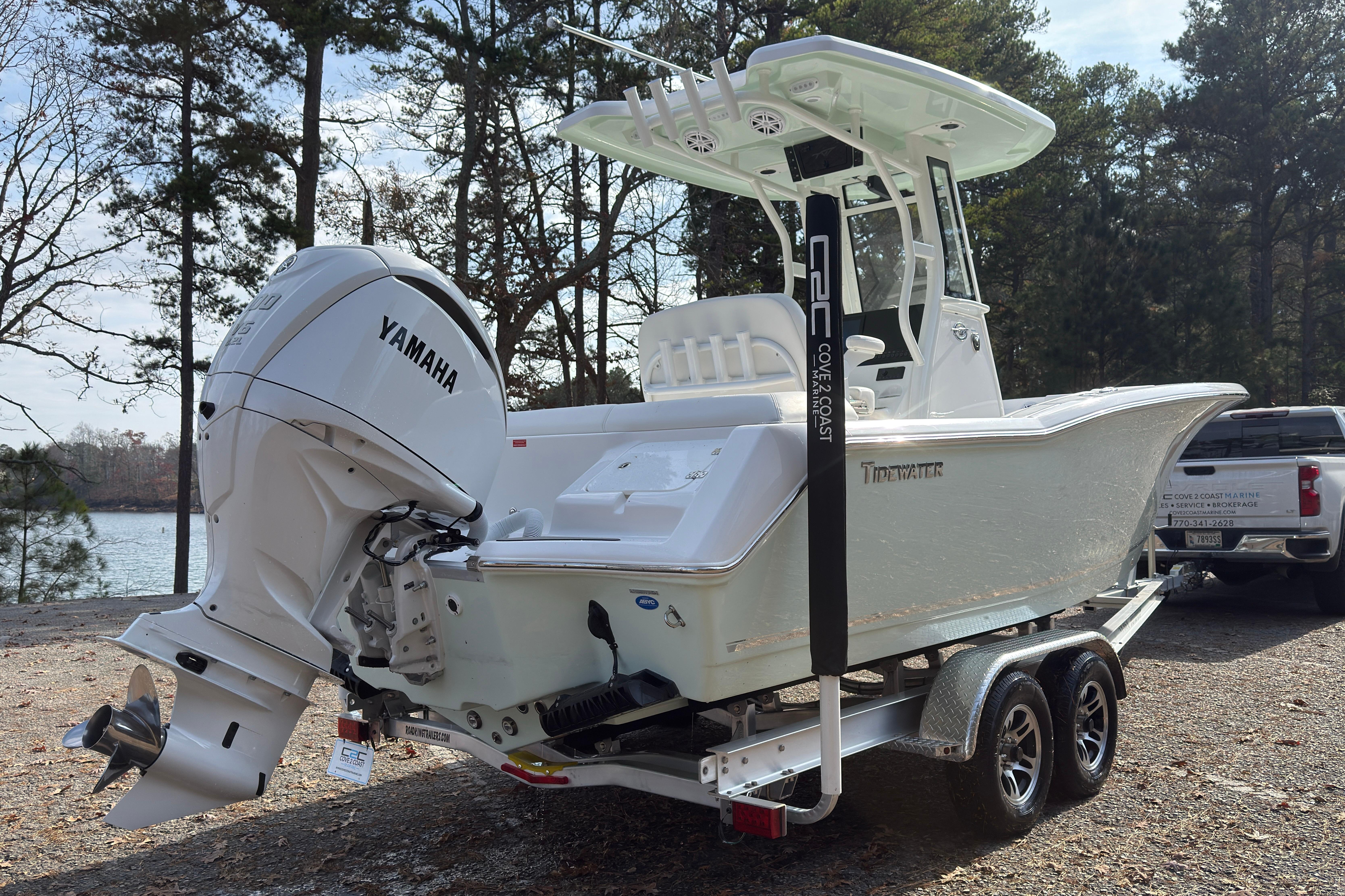 2026 Tidewater 232 LXF boat with Yamaha engine on trailer, parked near a lake.