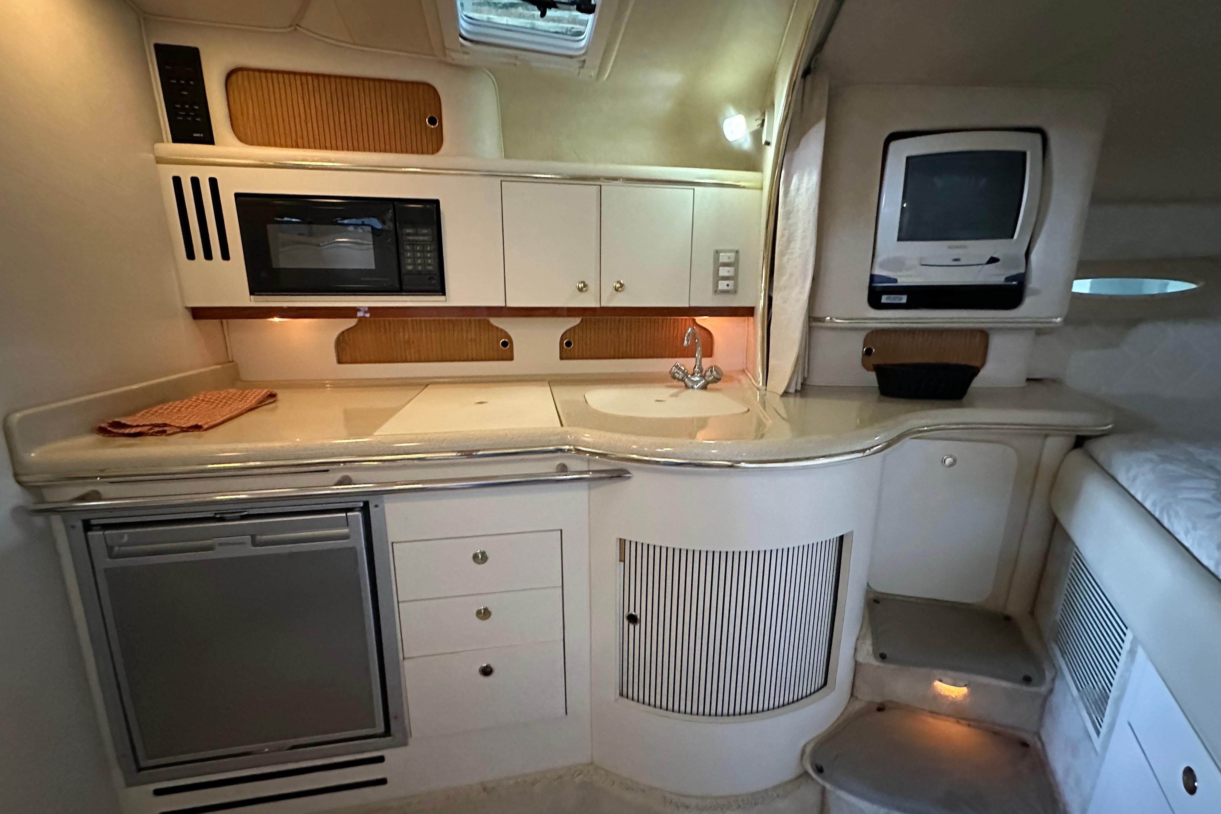Interior of 2000 Sea Ray Sundancer 310 yacht with kitchenette and compact appliances.