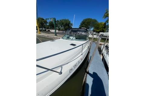 2000 Rinker Fiesta Vee 310 boat docked at marina under clear blue sky.