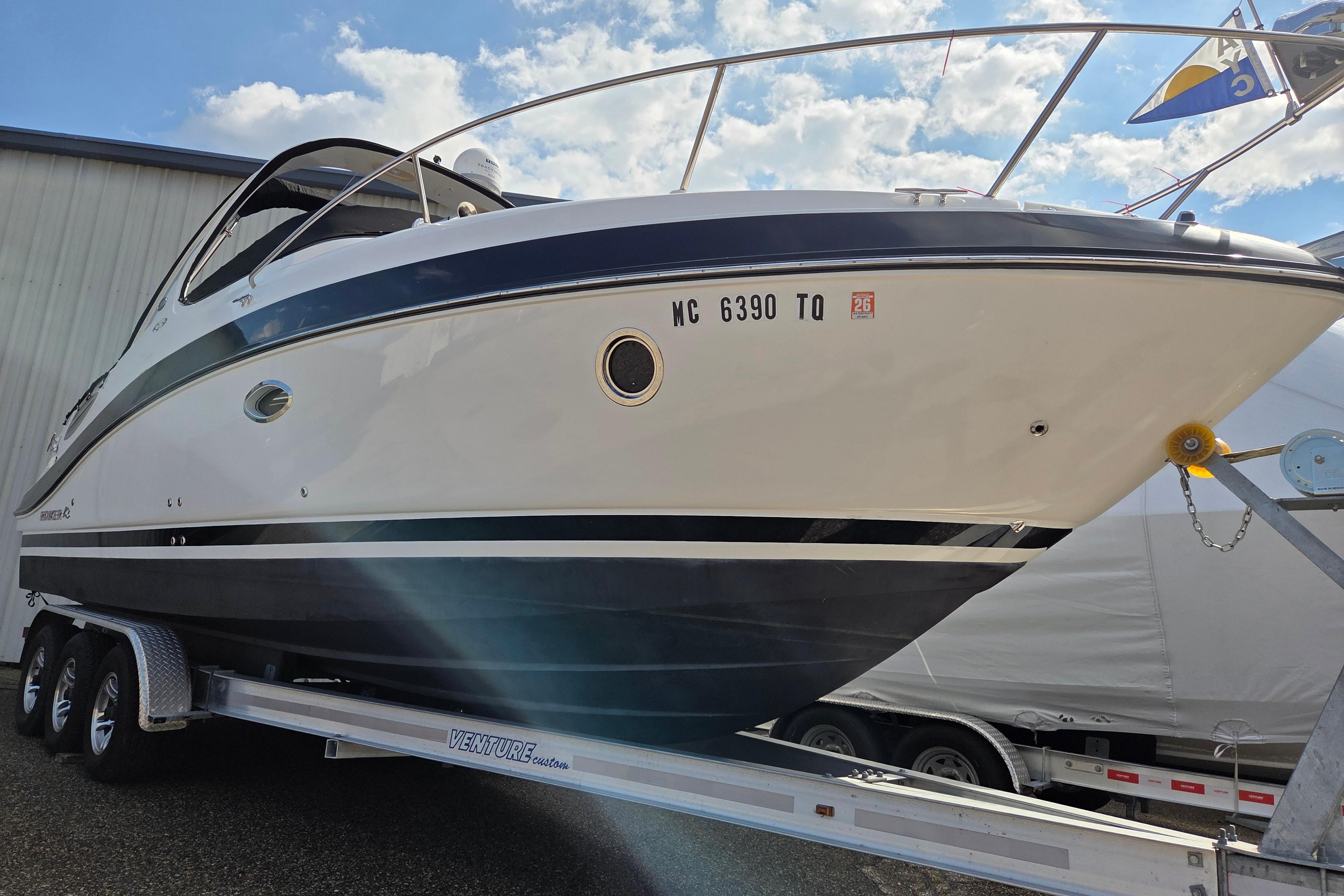 2014 Rinker 290 Express Cruiser on trailer under blue sky.