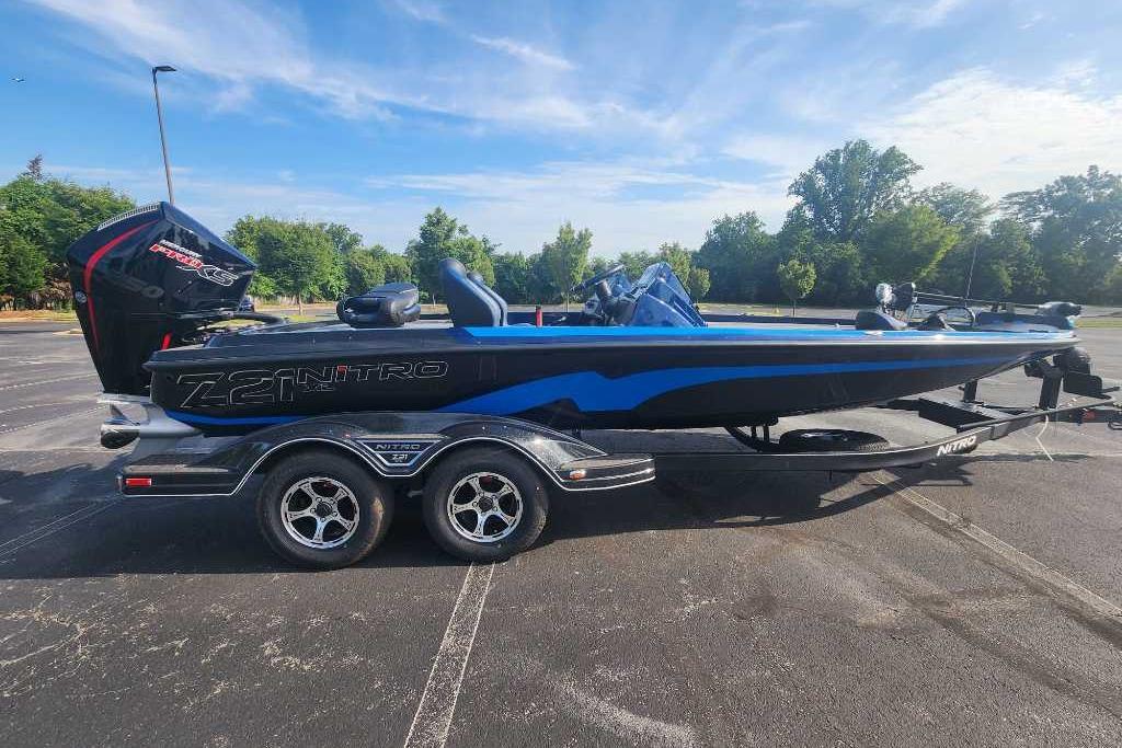 2025 Nitro Z21 XL boat on trailer in parking lot, under clear blue sky.