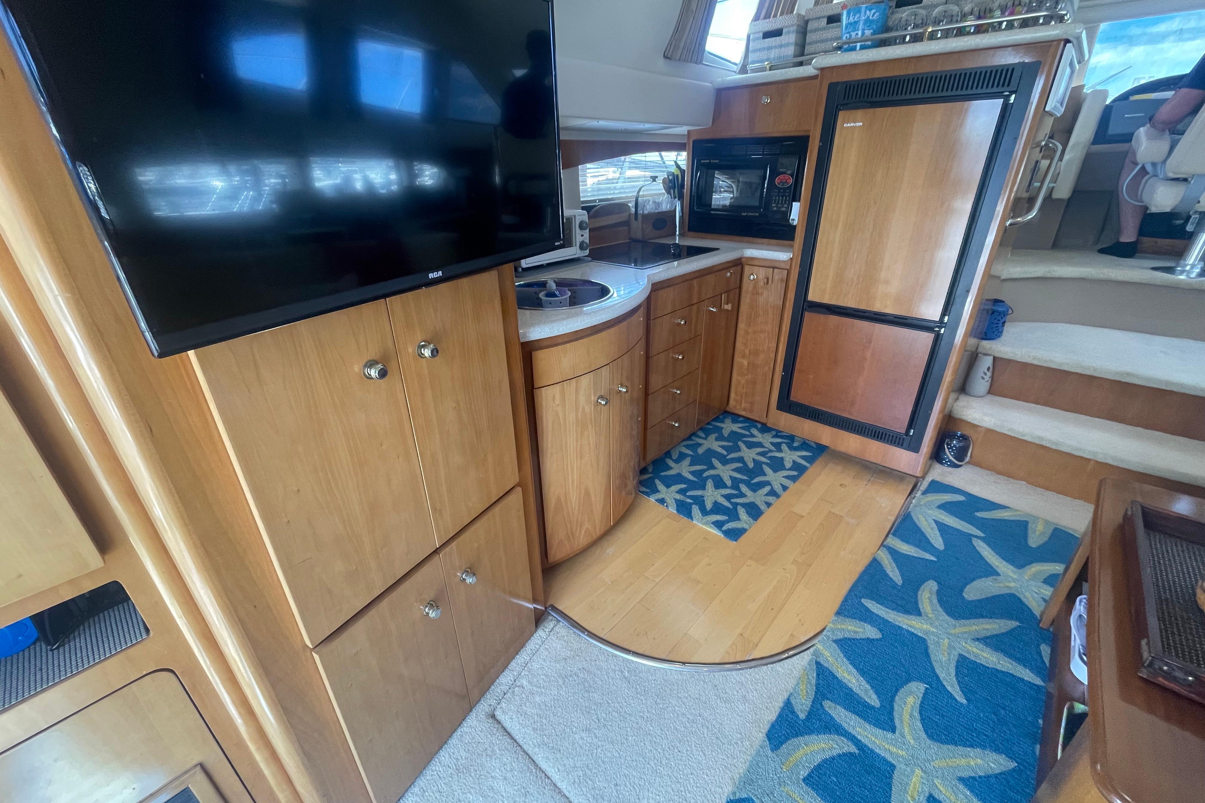 Interior of a 2002 Carver 410 Sport Sedan yacht with wood cabinetry and modern appliances.