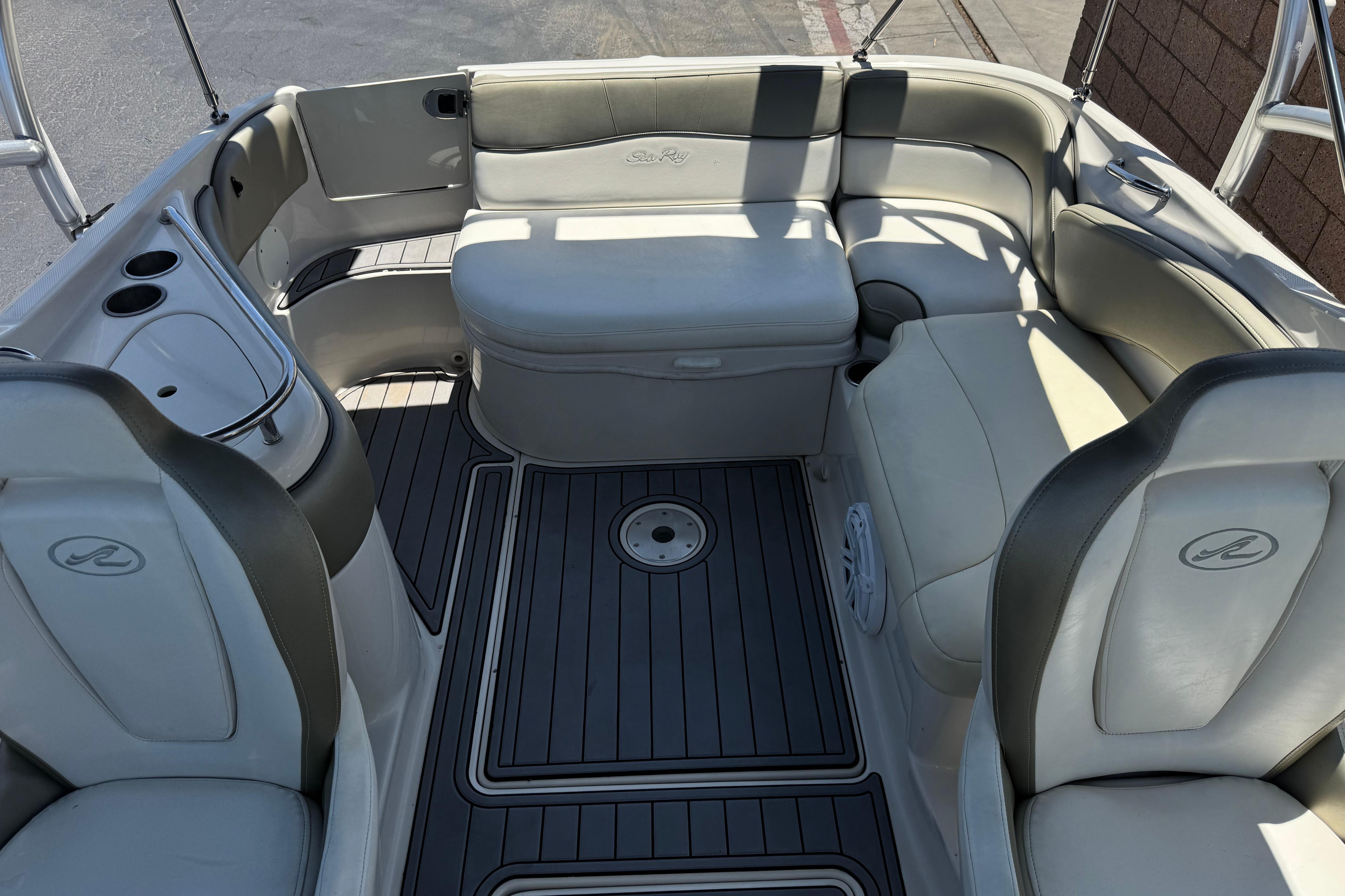 Interior of a 2007 Sea Ray 240 Sundeck boat with cushioned seating and cup holders.