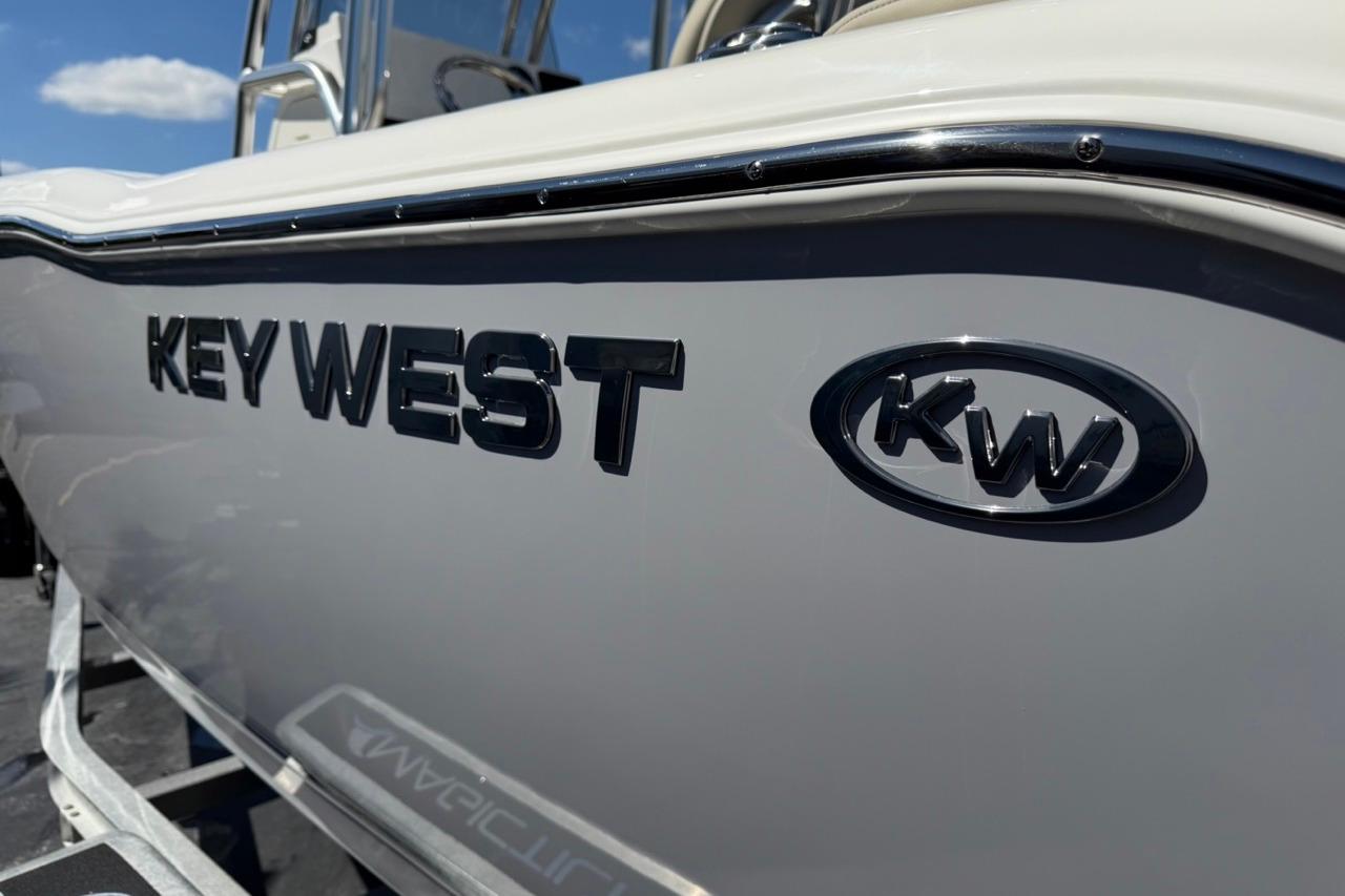 2026 Key West 203 FS boat with logo, side view under clear sky.