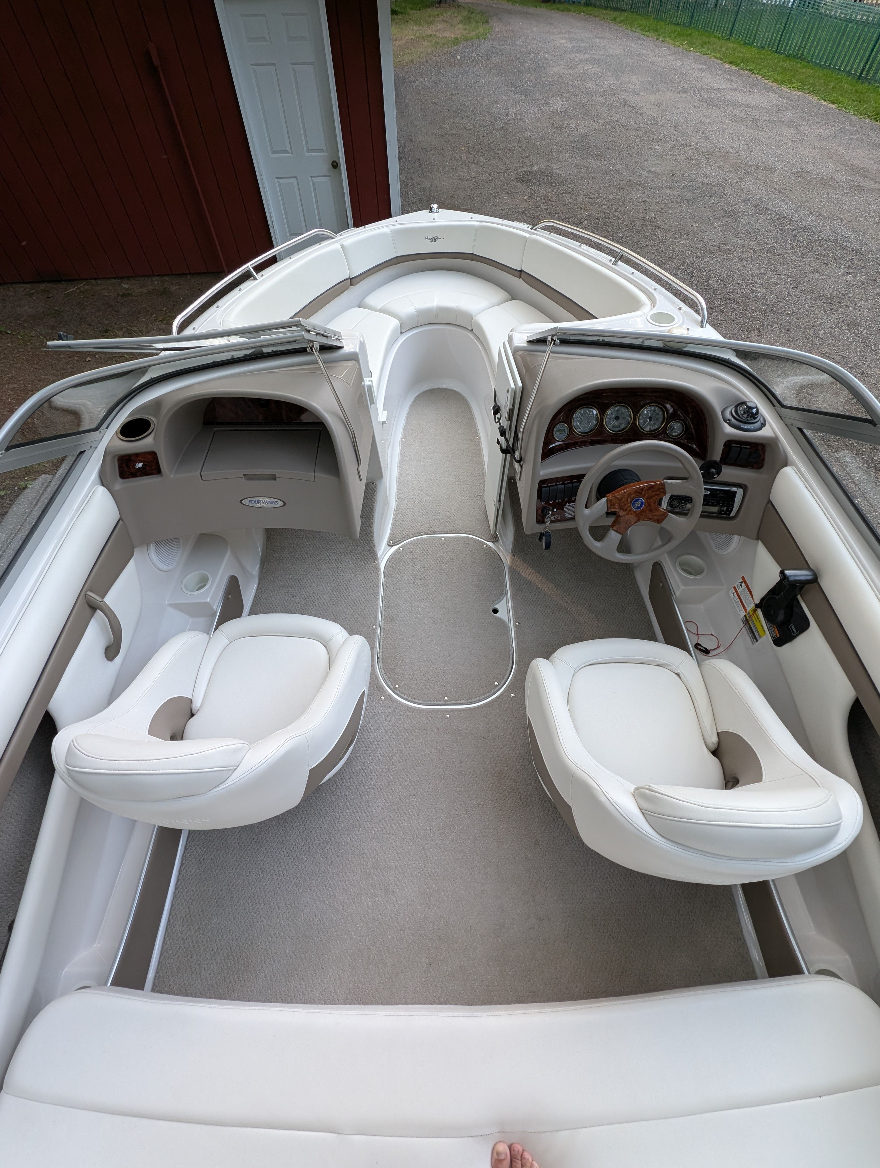 Interior view of a 2004 Four Winns 190 Horizon with two white seats and a helm station.