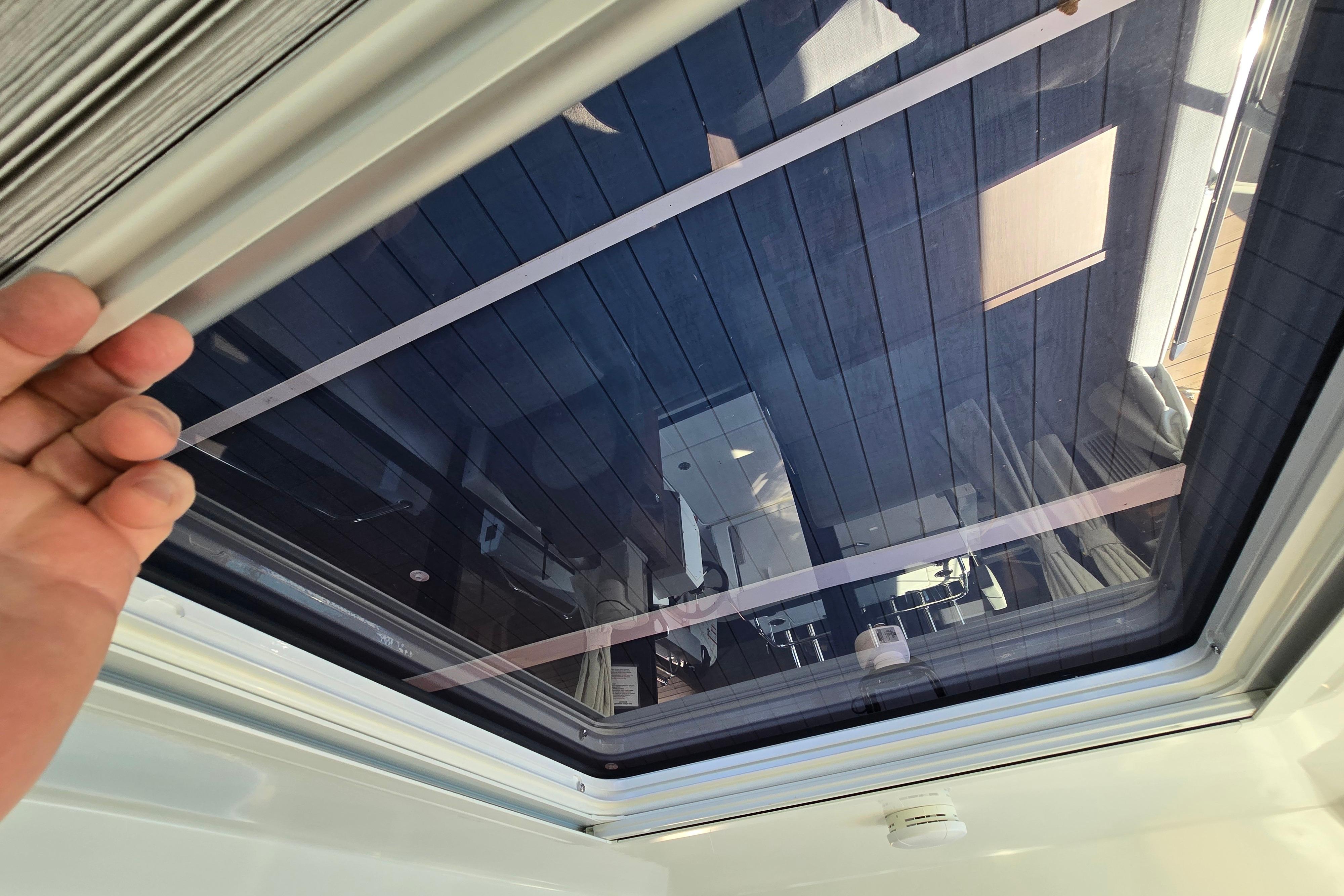 View through a skylight on a Jeanneau NC Sport 895 boat, showing the sky and surroundings.