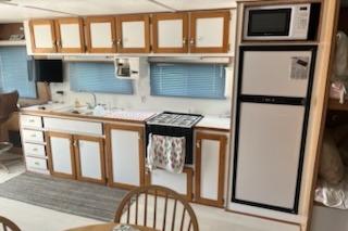 1994 PlayCraft 5215 kitchen interior with wooden cabinets, stove, and refrigerator.