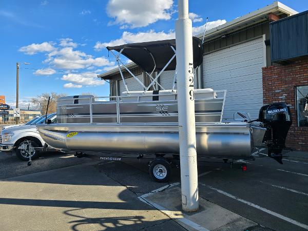 2025 Berkshire 20 CL pontoon boat with Suzuki outboard motor, parked outdoors.