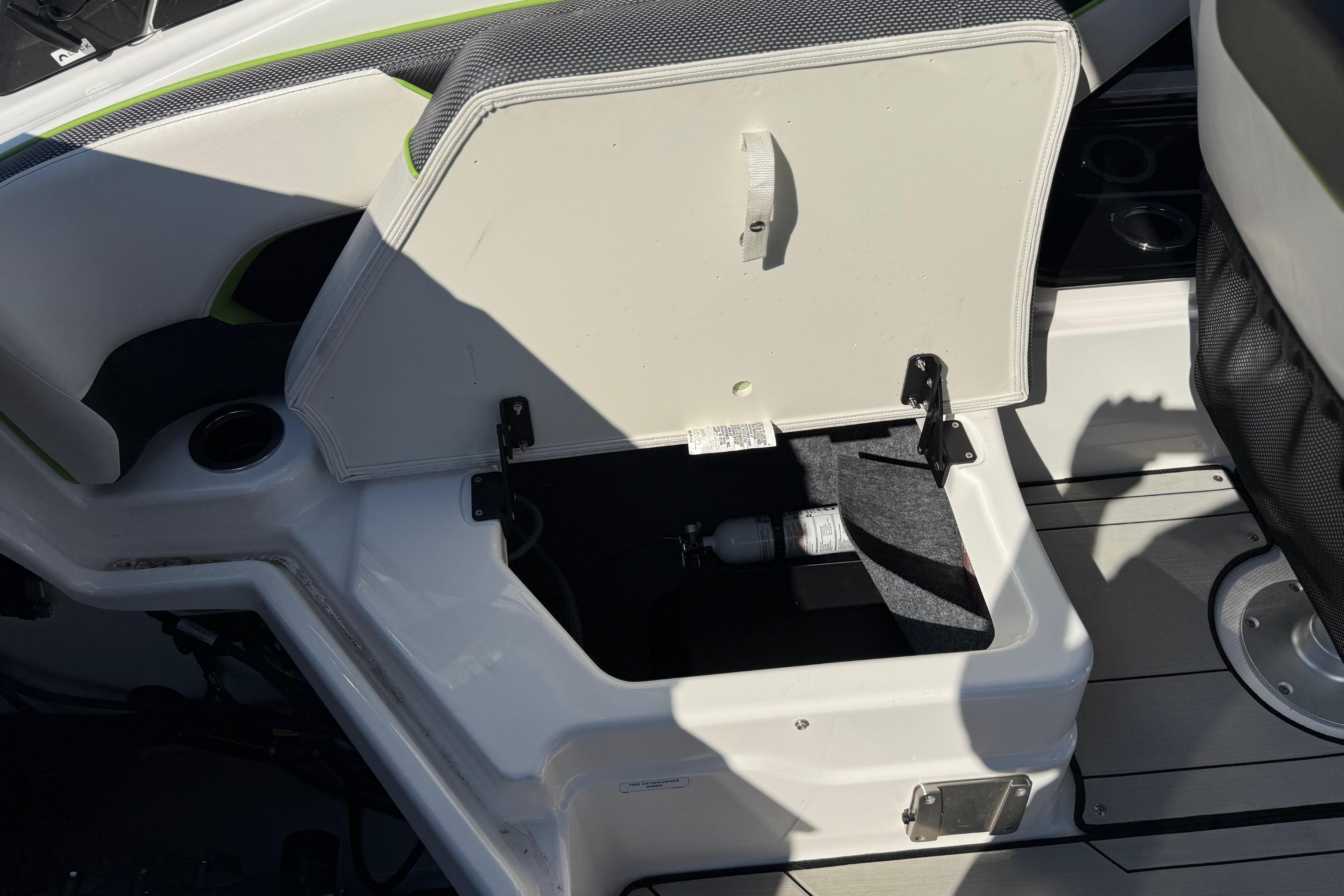 Open storage compartment on 2022 Yamaha Boats 212XE, revealing interior details.