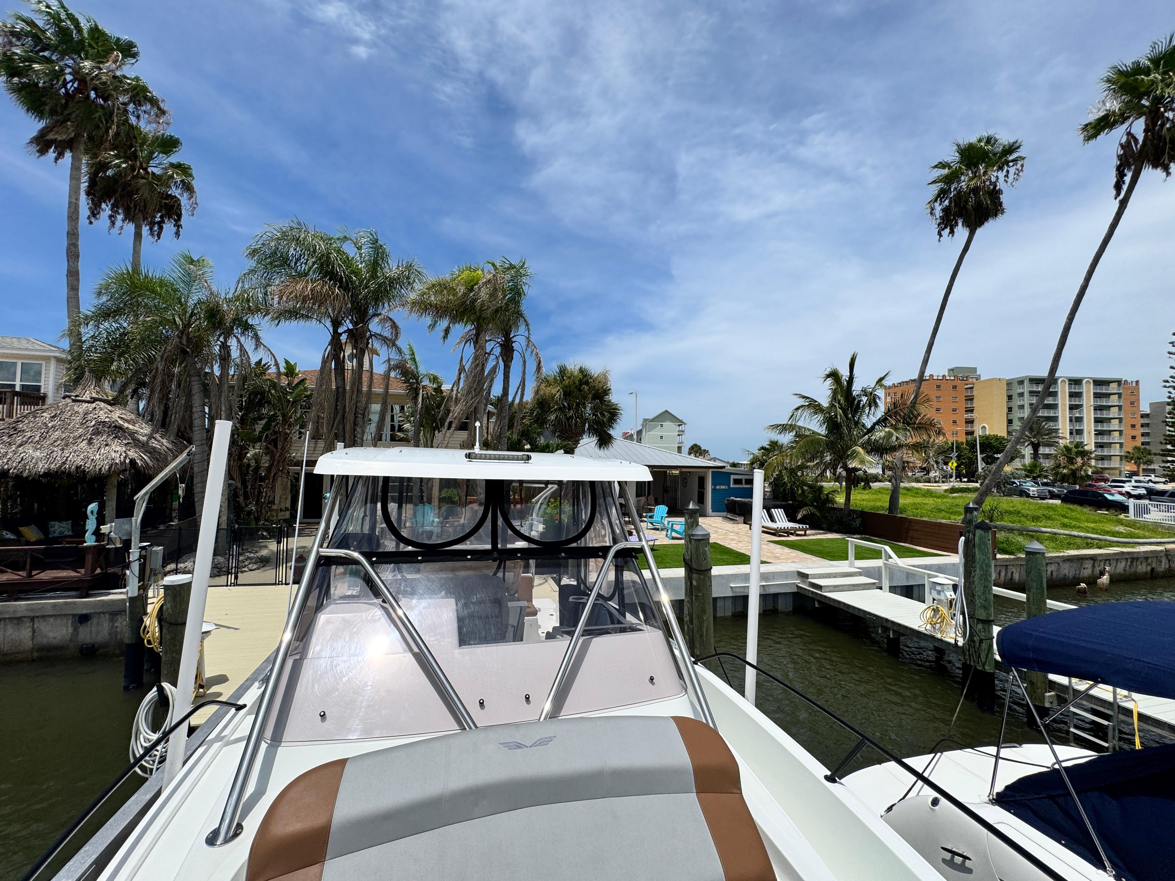 2022 Beneteau Flyer 9 SUNdeck docked near palm trees and waterfront buildings.