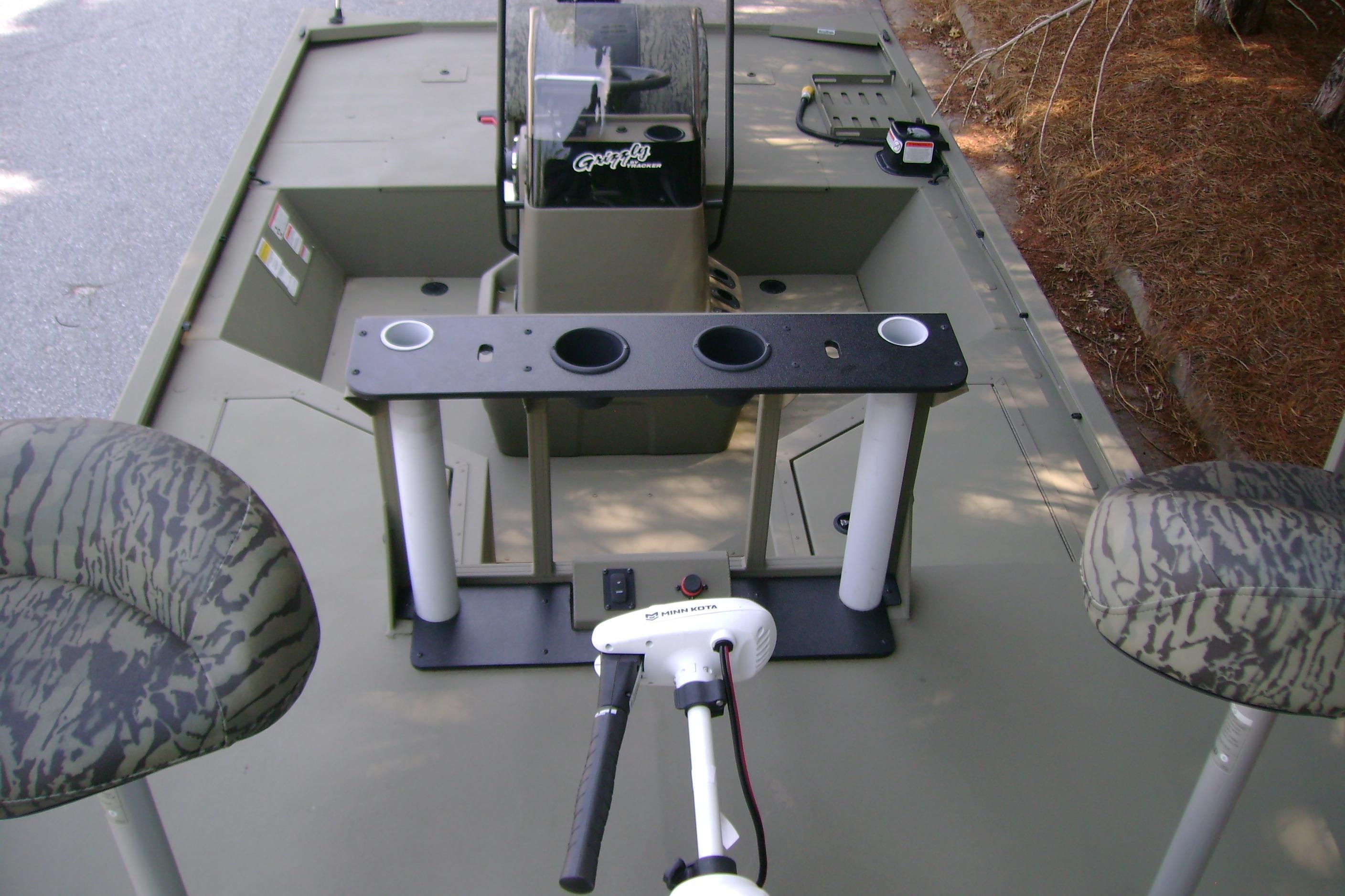 2026 Tracker Grizzly 2072 CC Sportsman boat interior with camo seats and fishing rod holders.