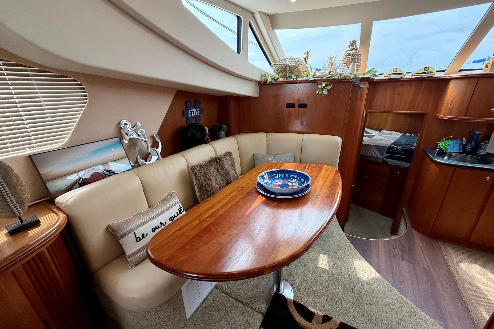 Interior of 2004 Silverton 39 Motor Yacht with cozy seating and elegant wooden table.
