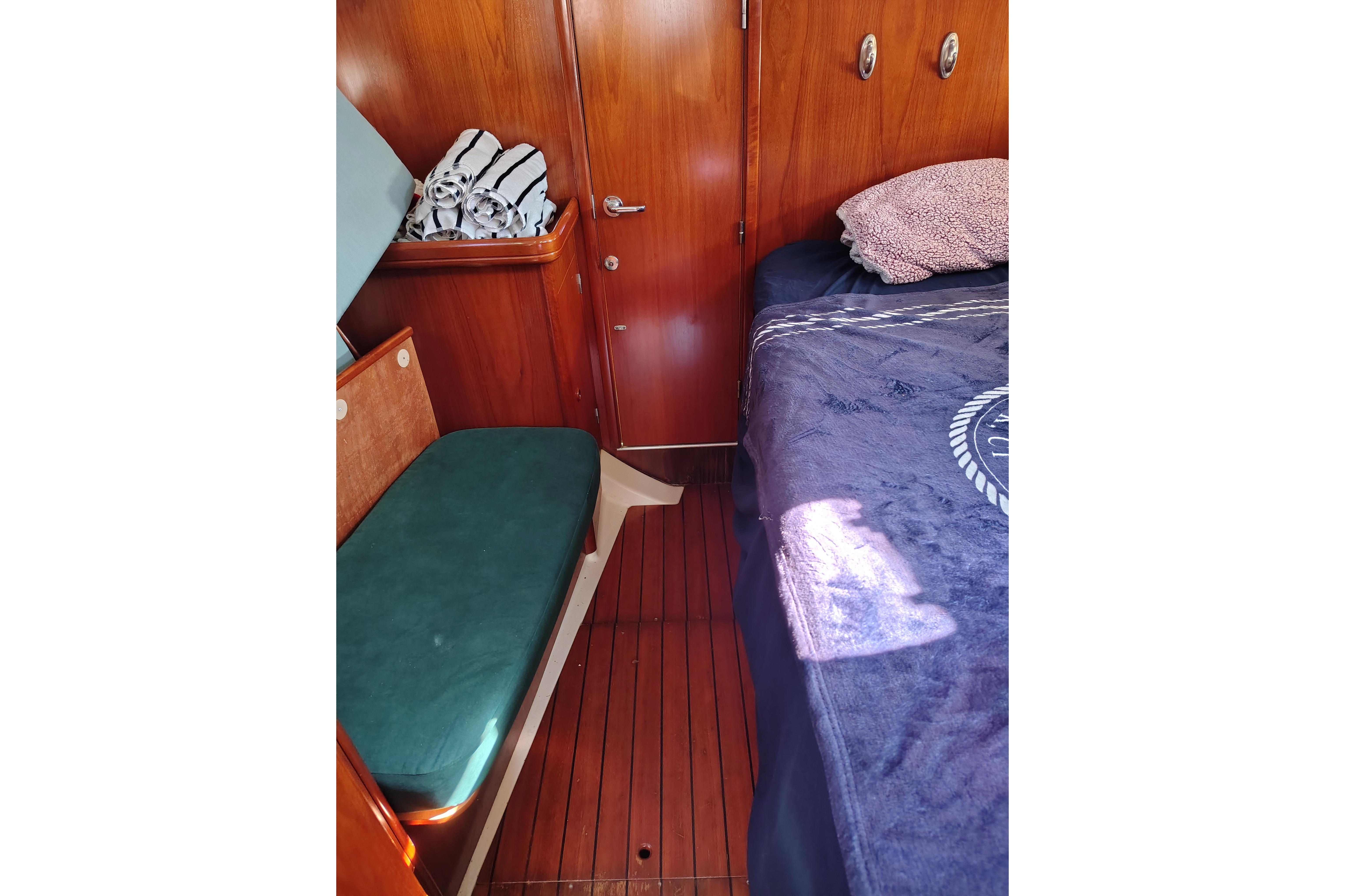 Cozy cabin interior of 2001 Beneteau Oceanis 411 sailboat with wooden finish and seating.