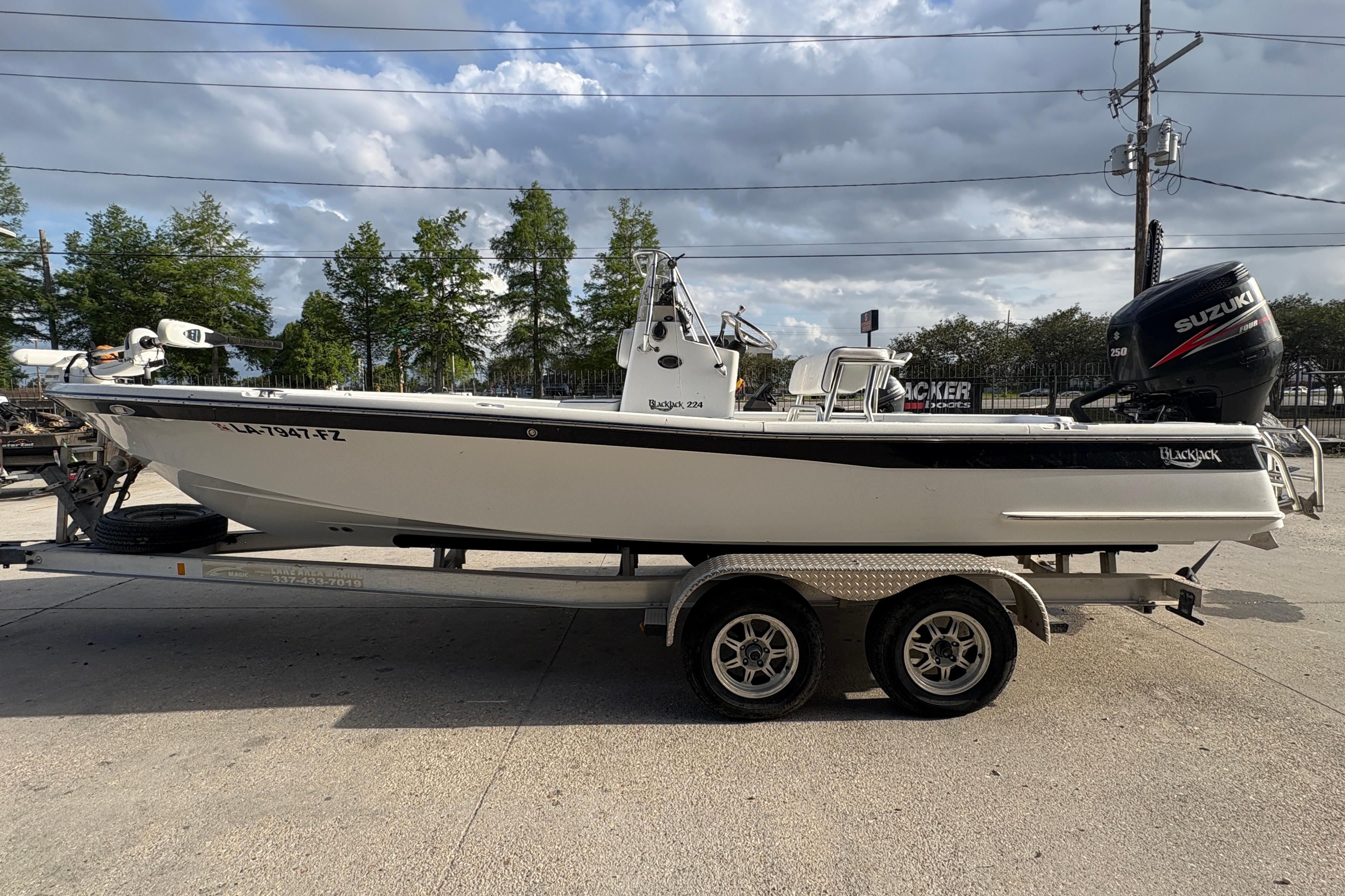 2012 BlackJack 224 boat on trailer with Suzuki engine, parked outdoors.
