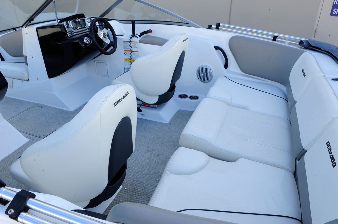 Interior of a 2011 Custom Challenger 180 boat with white seating and a steering console.