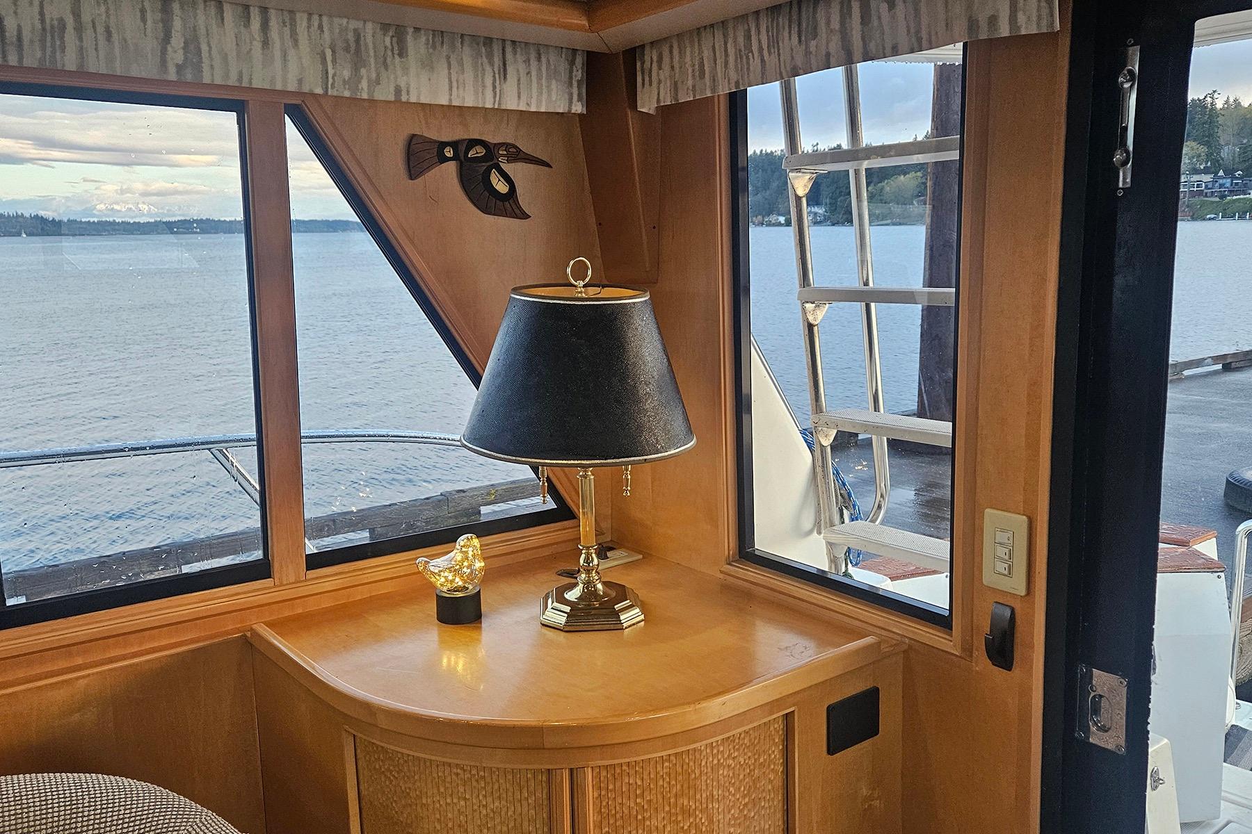 Cozy yacht interior with lamp, decorative bird, and scenic water view. Symbol 55, 1995 model.