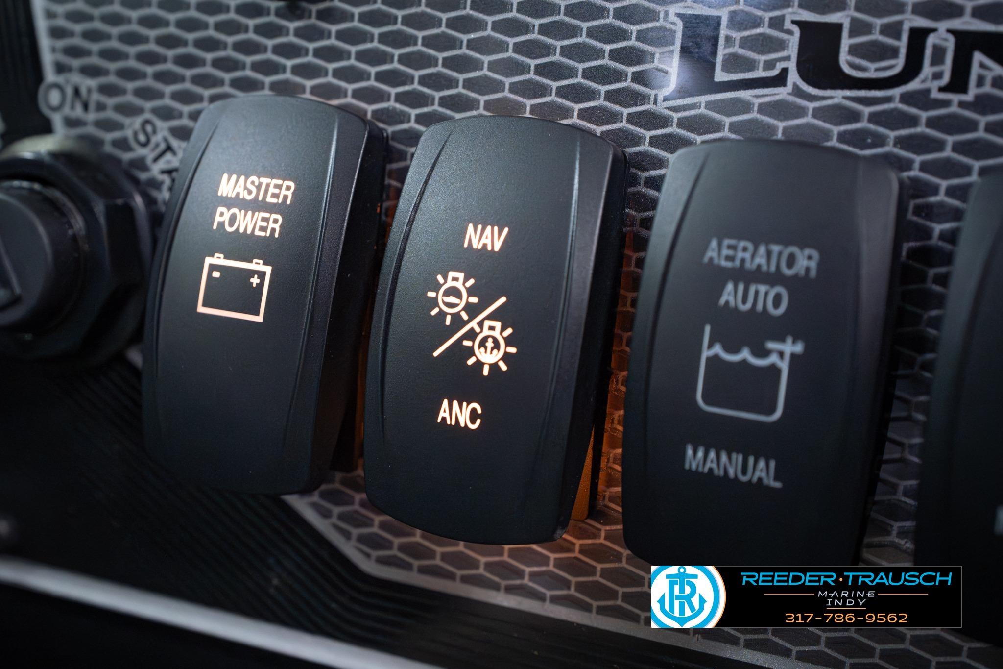 Control panel of 2026 Lund 1875 Impact XS SS boat with illuminated switches.