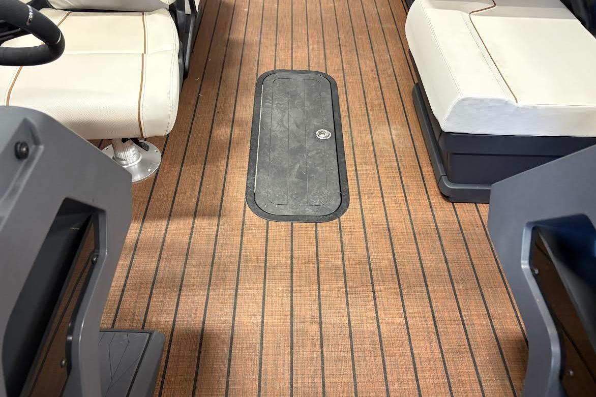 2023 Manitou EXPLORE 26 SHP 575 interior with wood-patterned flooring and cushioned seating.