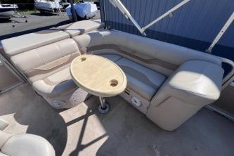 2012 Avalon Tahoe boat interior with beige seating and round table.