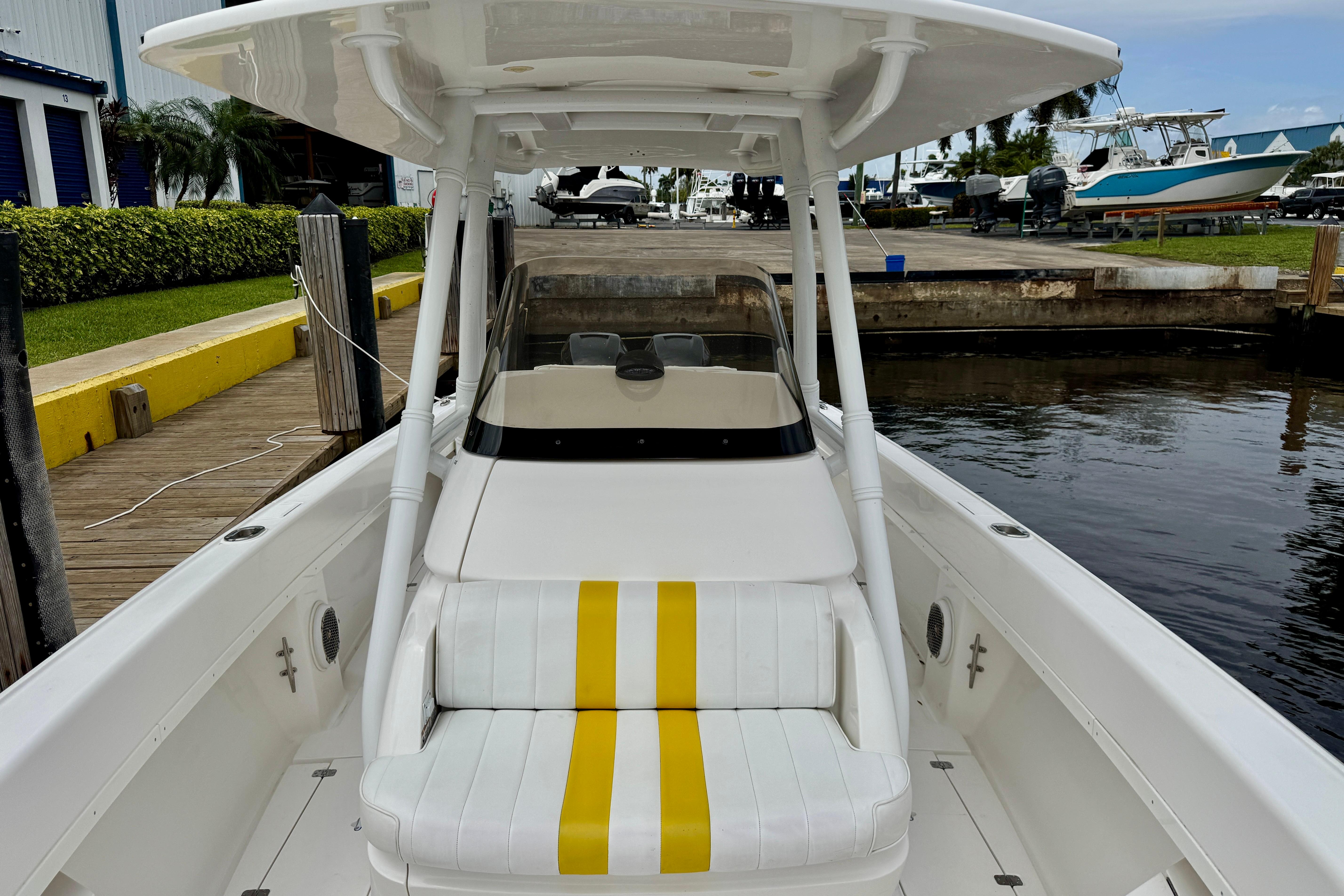 2013 Intrepid 300 Center Console boat docked, featuring white and yellow seating.