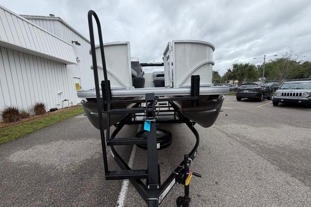 2026 Sun Tracker Party Barge 16 DLX pontoon boat on trailer in parking lot.