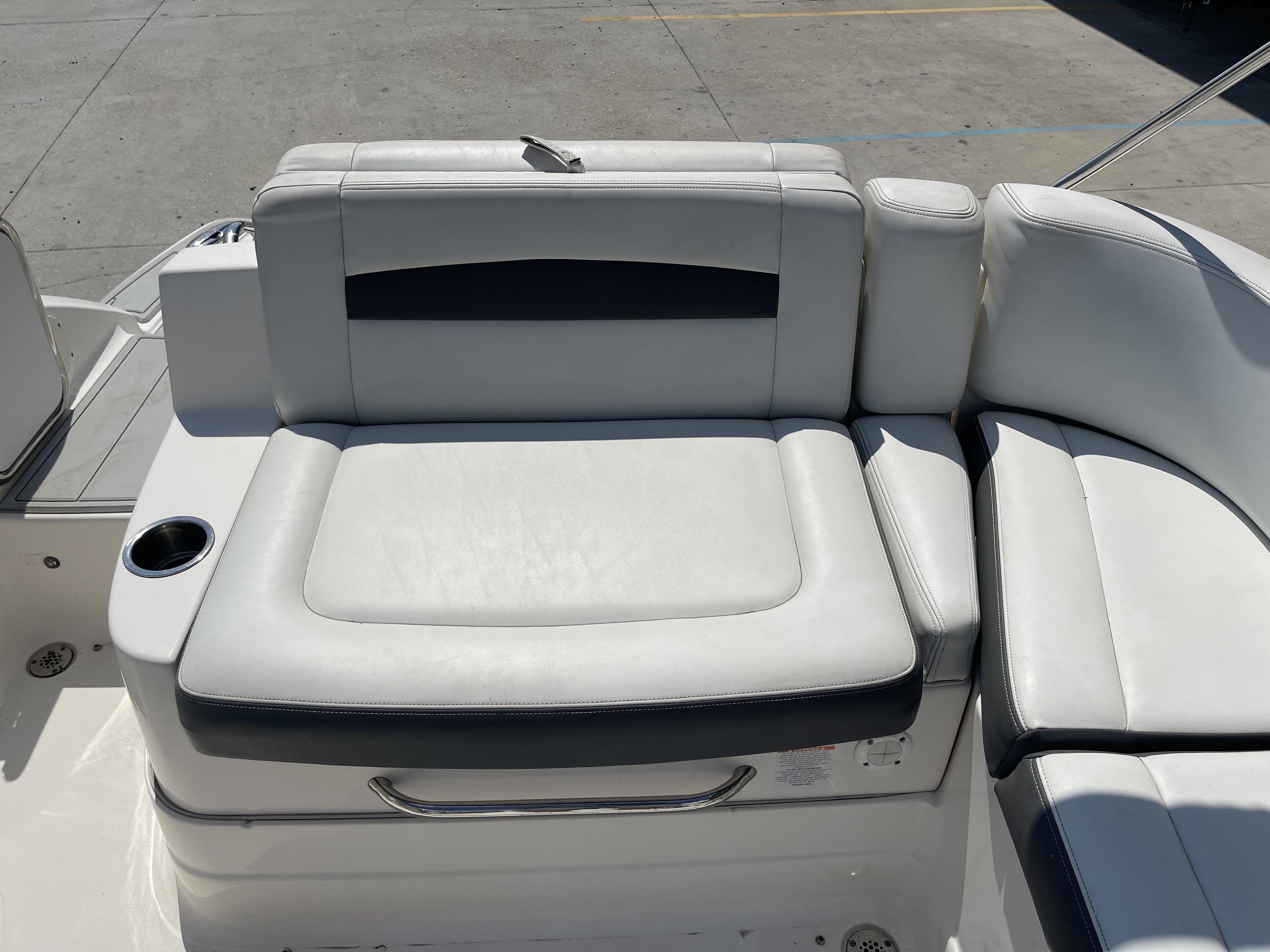 2014 Chaparral Sunesta 224 boat seating with cup holder, featuring white and black upholstery.