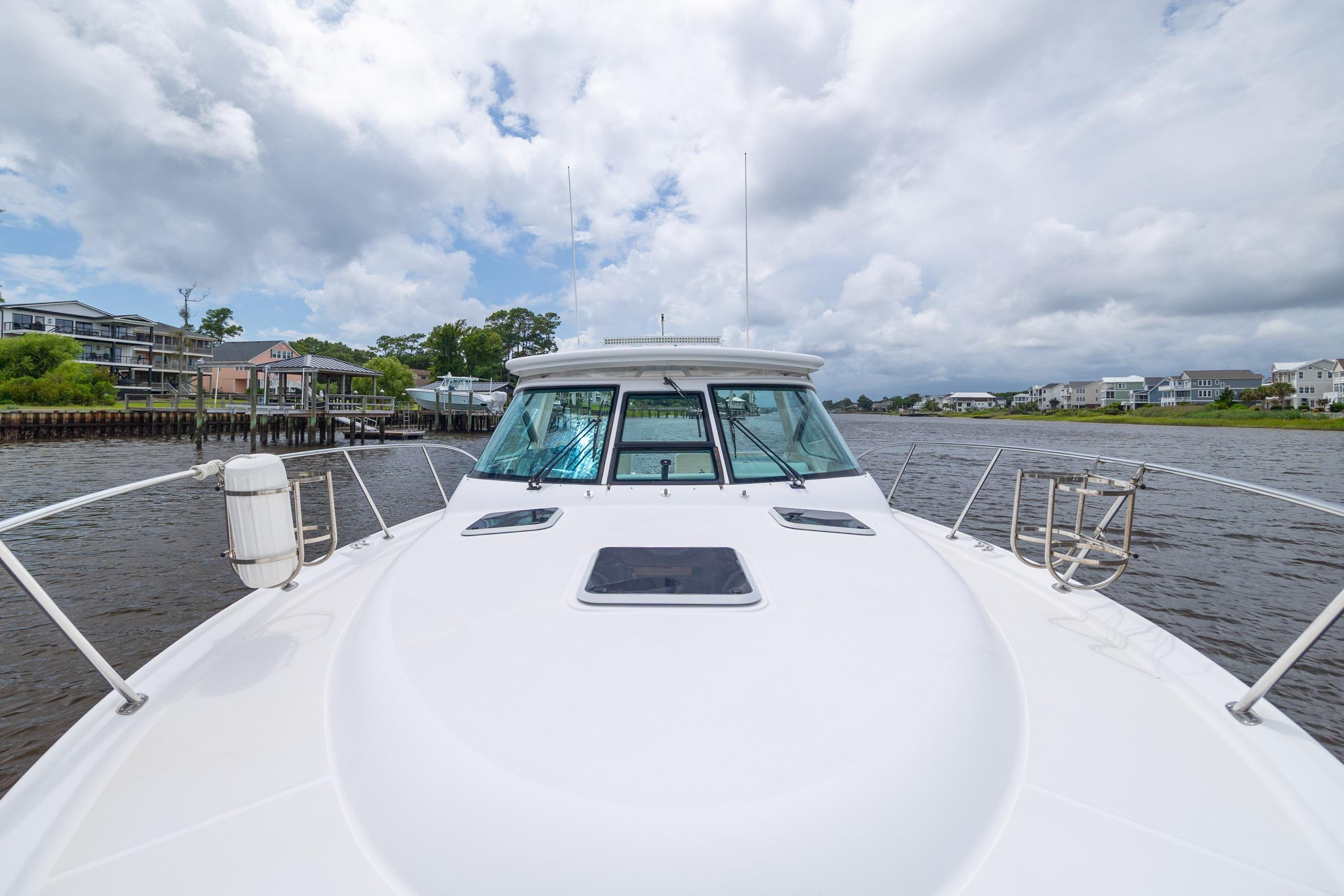 2004 Tiara Yachts 3200 Open cruising on a scenic waterway under cloudy skies.