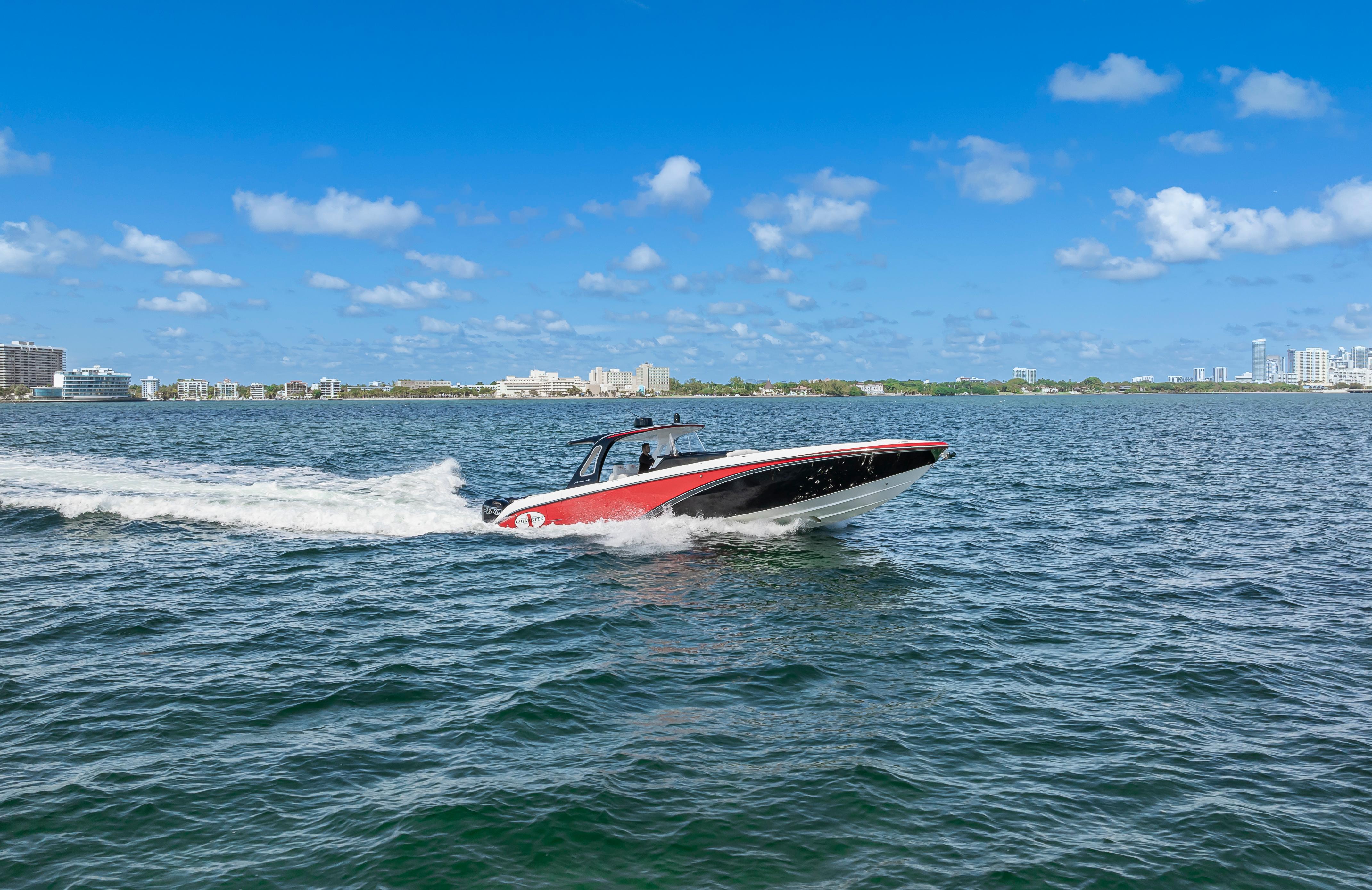 2016 Cigarette 41 GTR speedboat cruising on open water under a clear blue sky.
