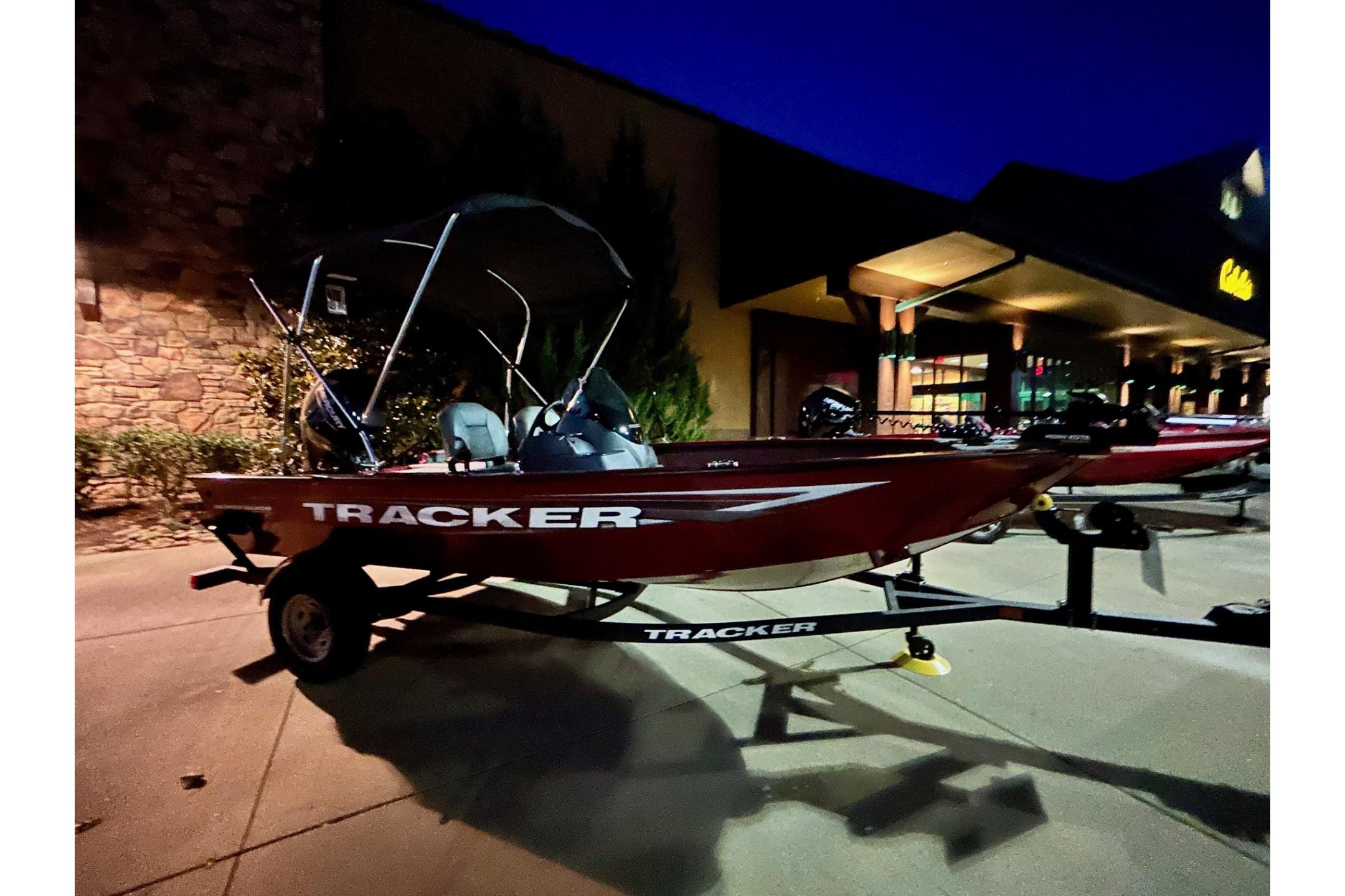 2026 Tracker Super Guide V-16 SC boat on trailer at night, parked outside a building.